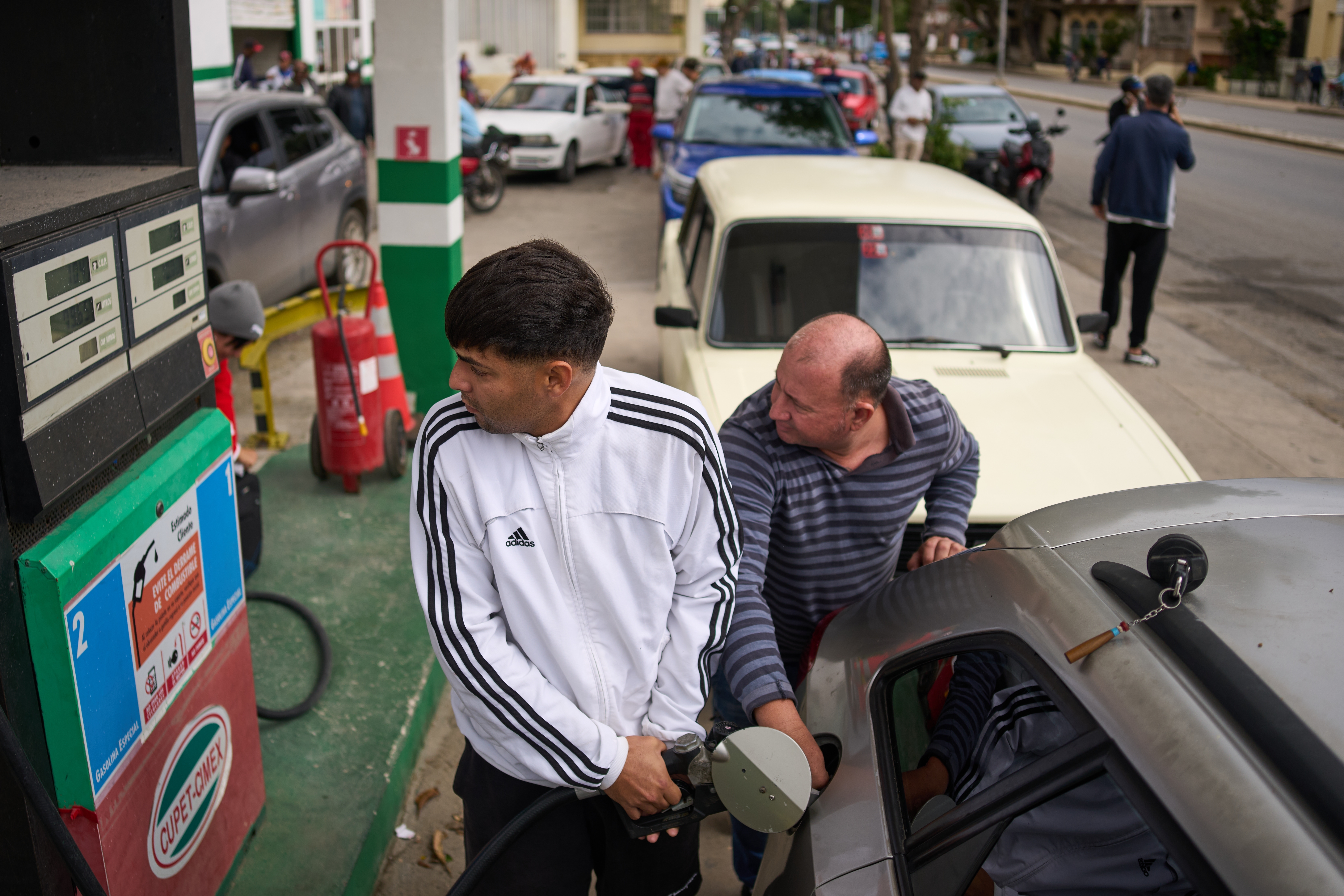 A driver refuels at a gas station as others wait behind in a long line in Havana, Cuba, Friday, Jan. 30, 2026. (AP Photo/Ramon Espinosa)