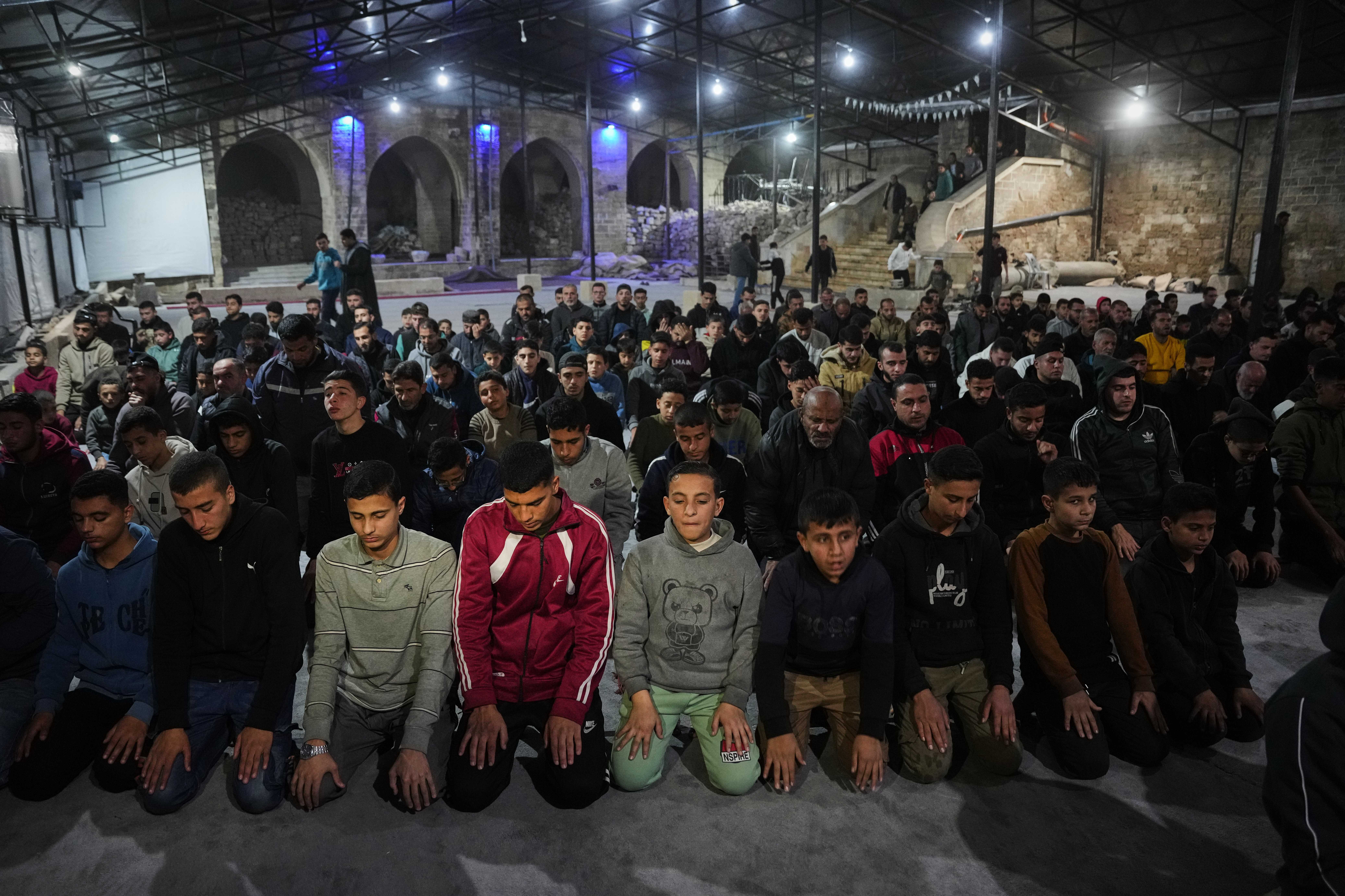 Muslim worshippers perform evening tarawih prayer on the first night of the holy fasting month of Ramadan at the Great Omari Mosque, which was damaged during the Israel-Hamas war, in Gaza City