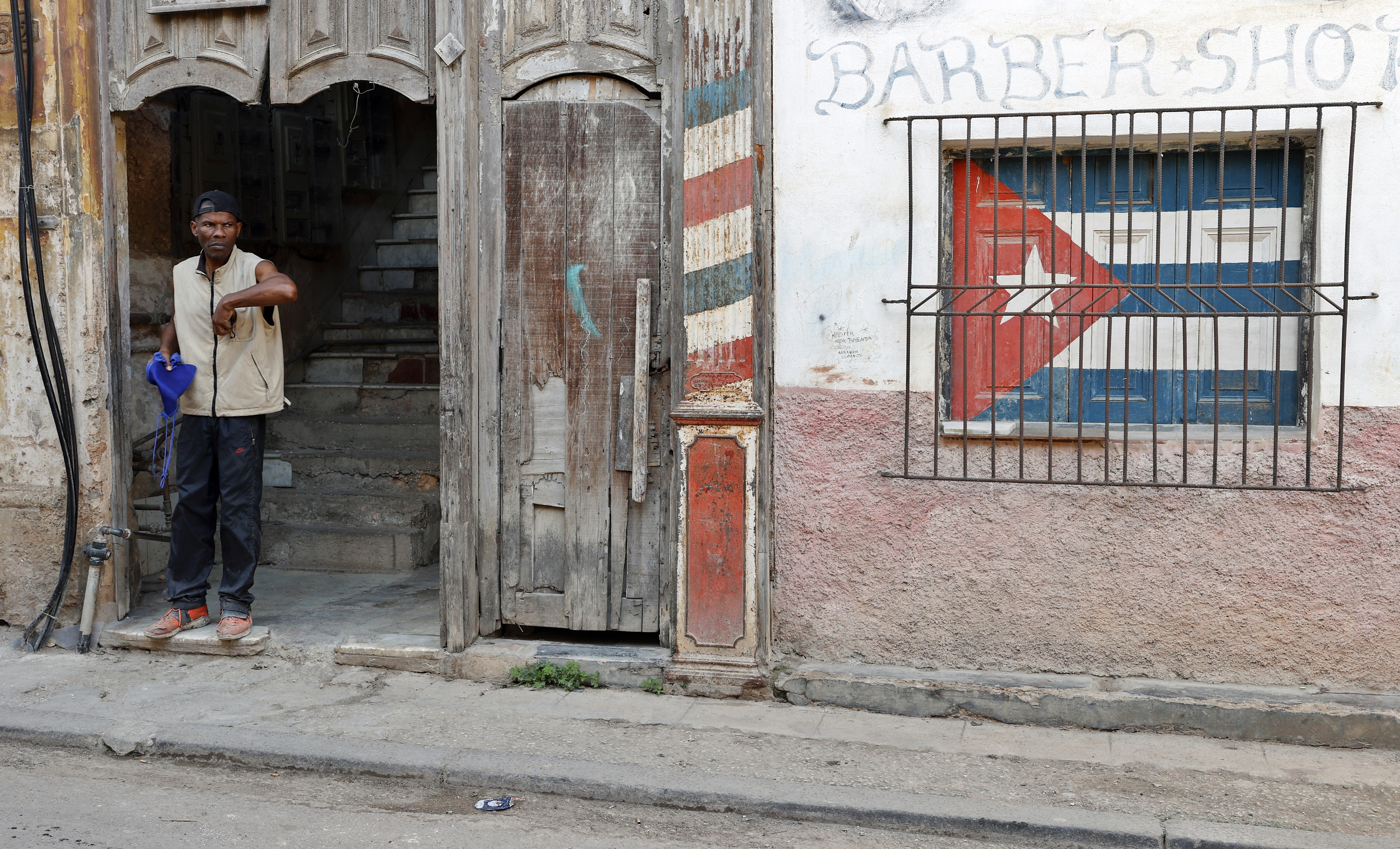 A person waits at the entrance to a house in Havana, Cuba, 25 March 2026.