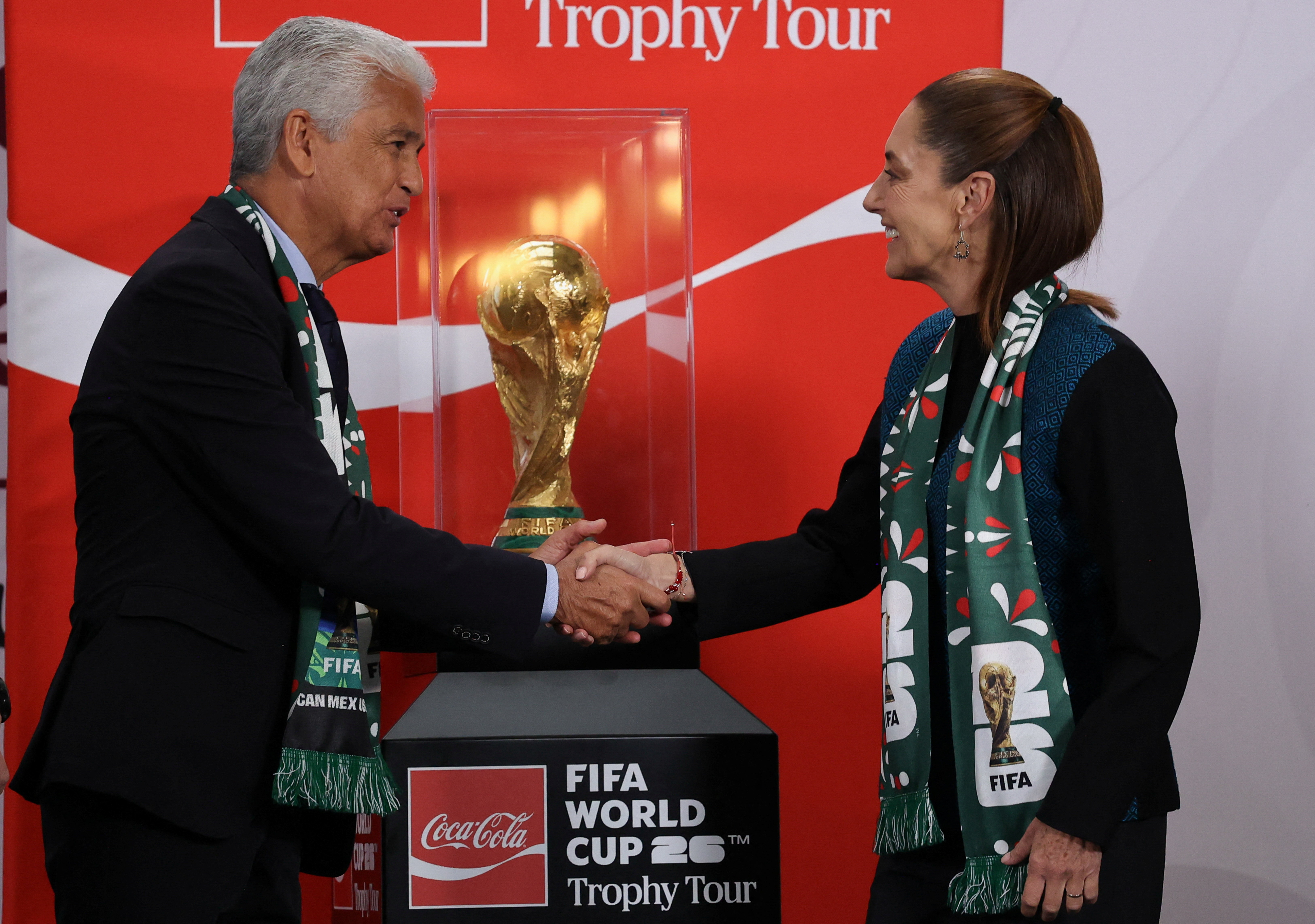 Brazilian former soccer player Jose Roberto Gama de Oliveira 'Bebeto' shakes hands with Mexico's President Claudia Sheinbaum in front of the FIFA World Cup trophy during her morning press conference at the National Palace, in Mexico City
