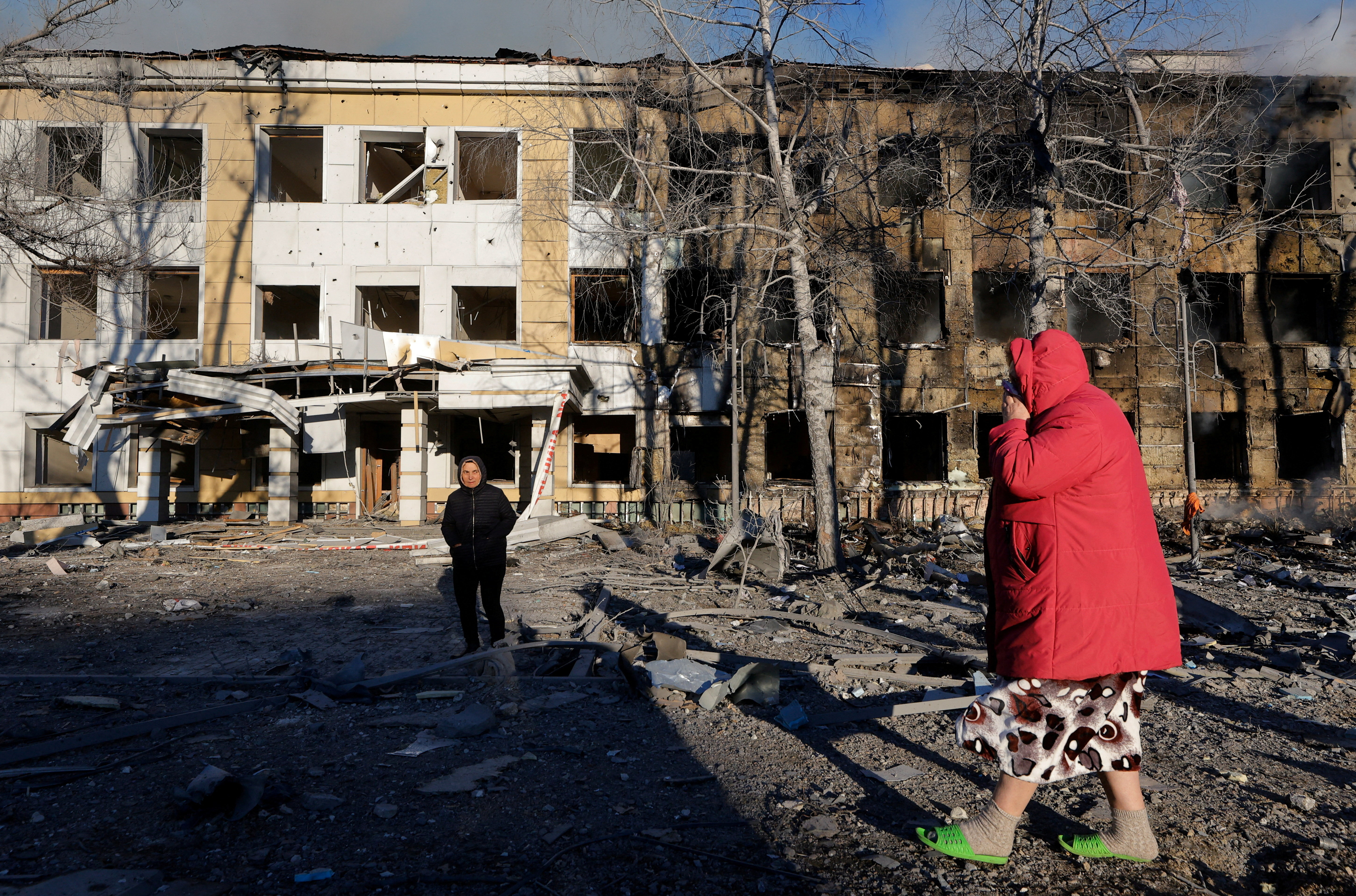 People walk near a building of a children's hospital, damaged by recent shelling that local Russian-installed authorities called a Ukrainian military strike, while the hospital was under maintenance with no patients inside, in the course of the Russia-Ukraine military conflict in Donetsk, a Russian-controlled city of Ukraine, March 8, 2026. REUTERS/Alexander Ermochenko TPX IMAGES OF THE DAY