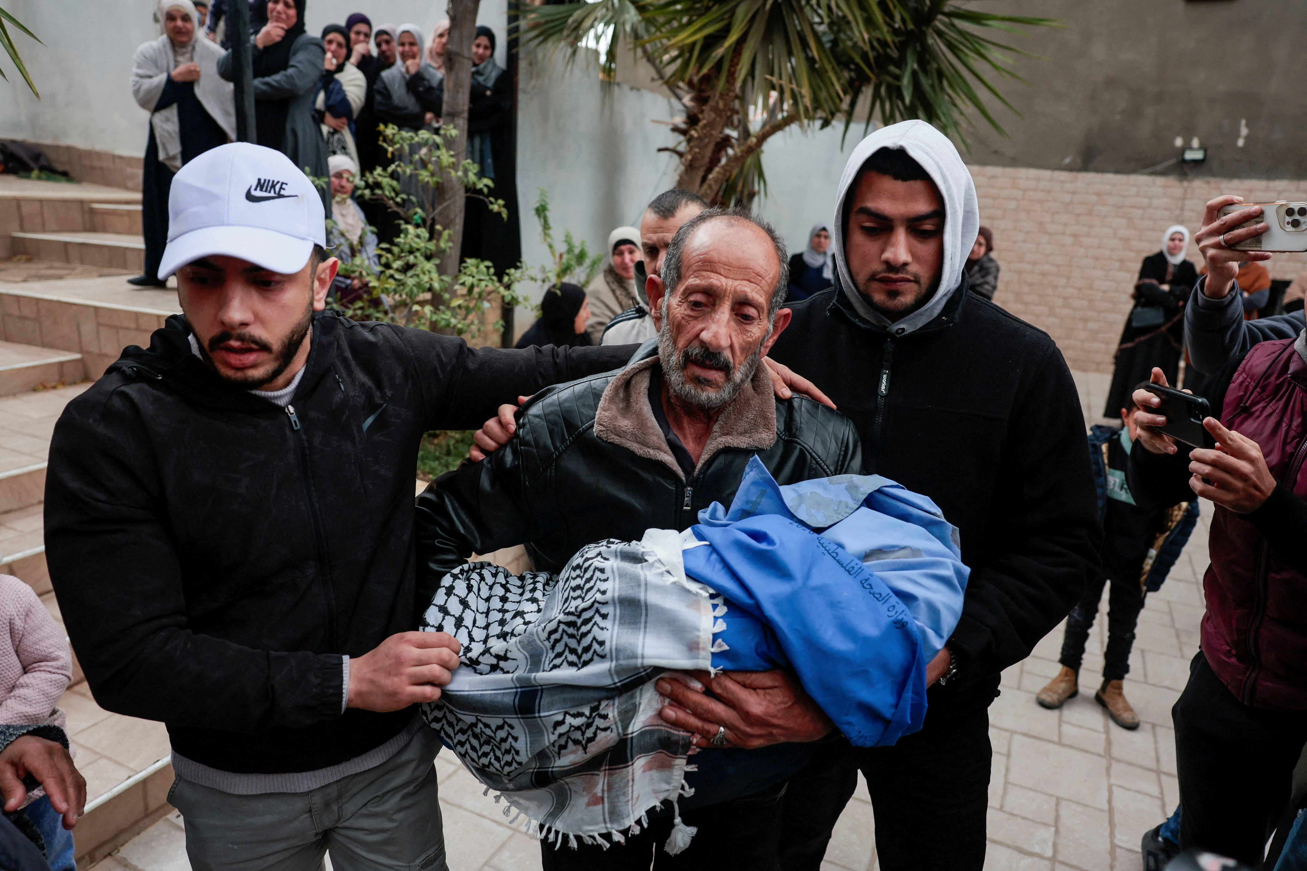 A mourner carries the body of one of the children killed in the attack