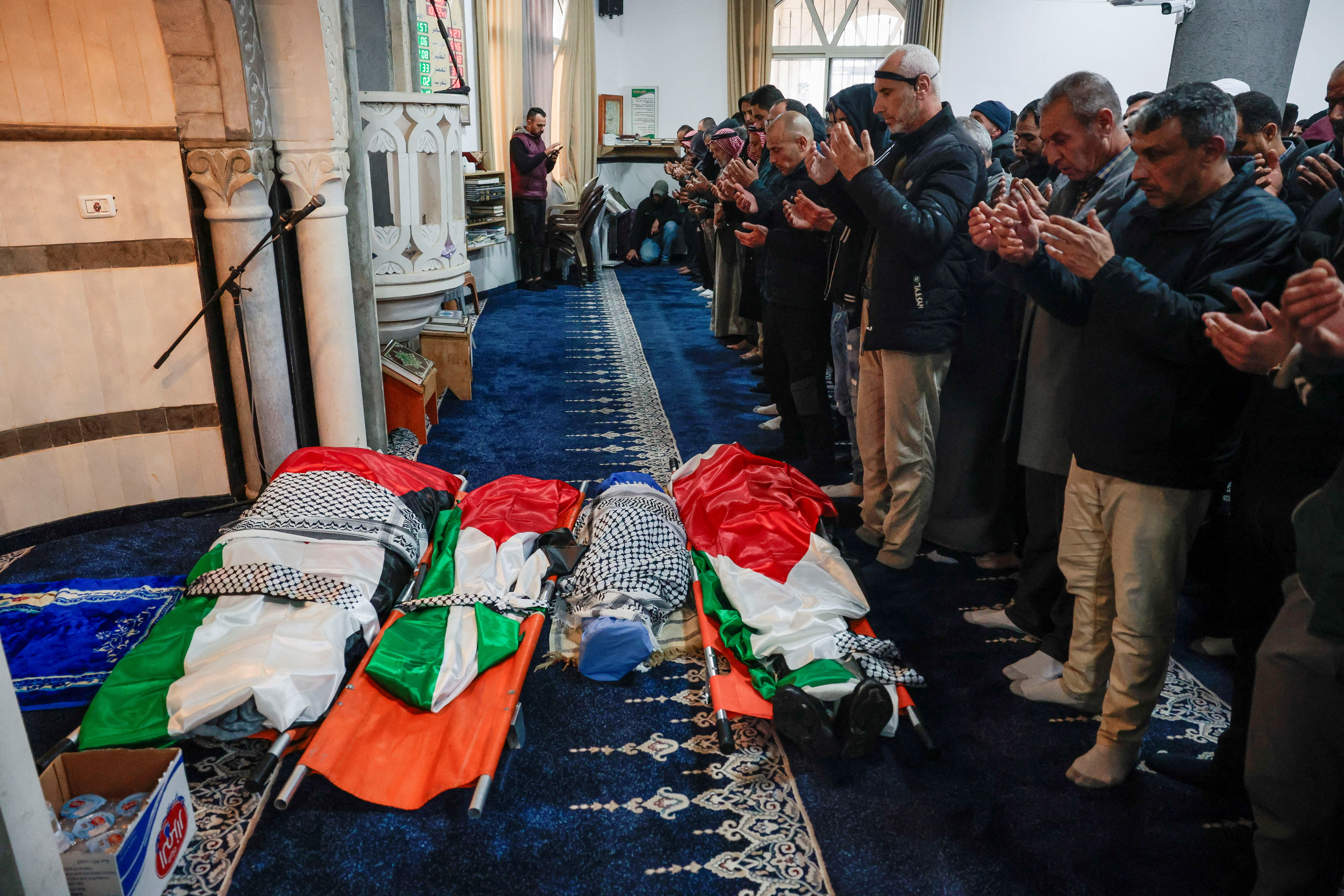 Mourners pray in front of the bodies of the Palestinian family, parents and their two children, who were killed by Israeli forces in Tammun town near Tubas, occupied West Bank