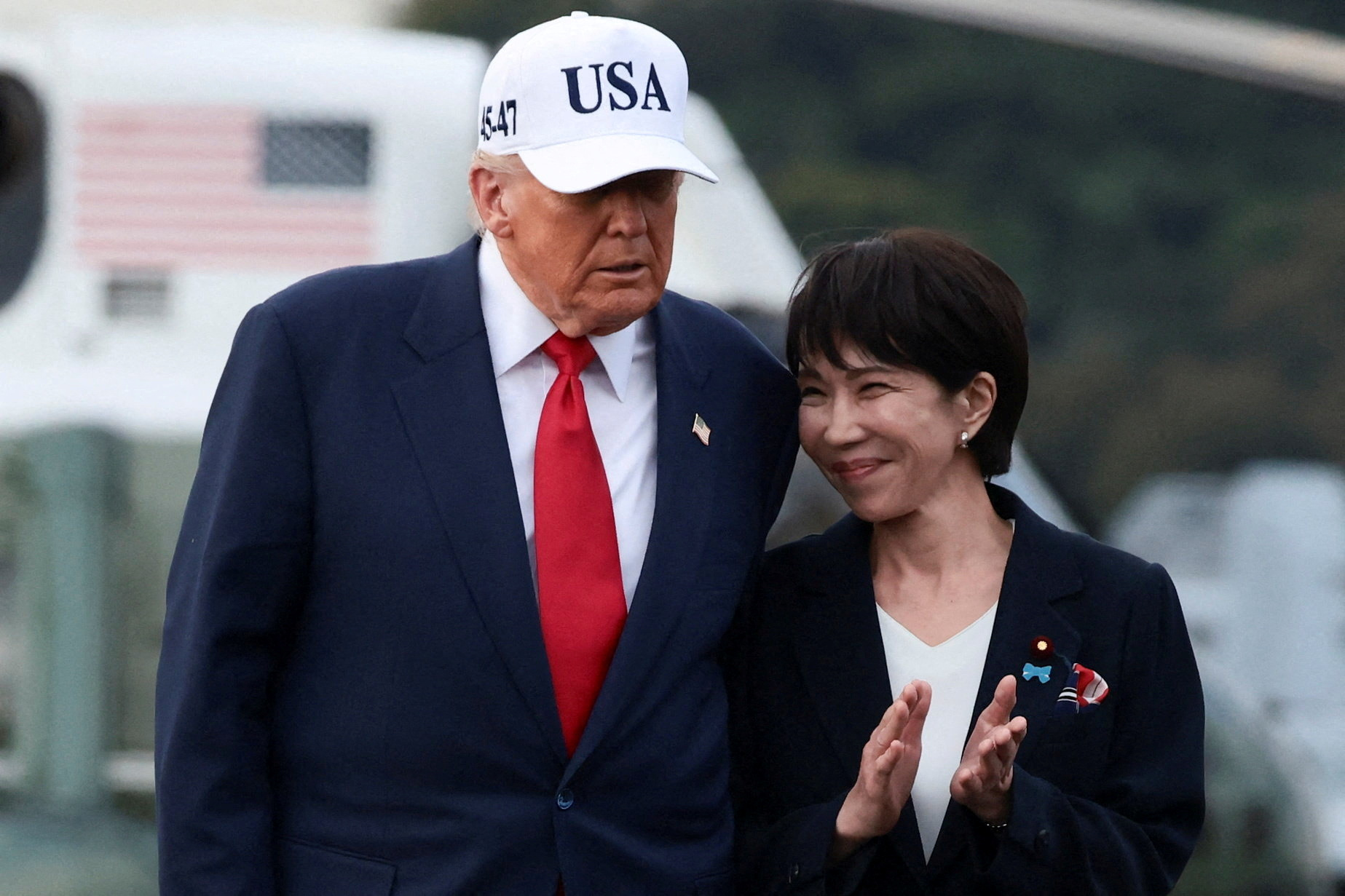 US President Donald Trump walks with Japanese Prime Minister Sanae Takaichi.