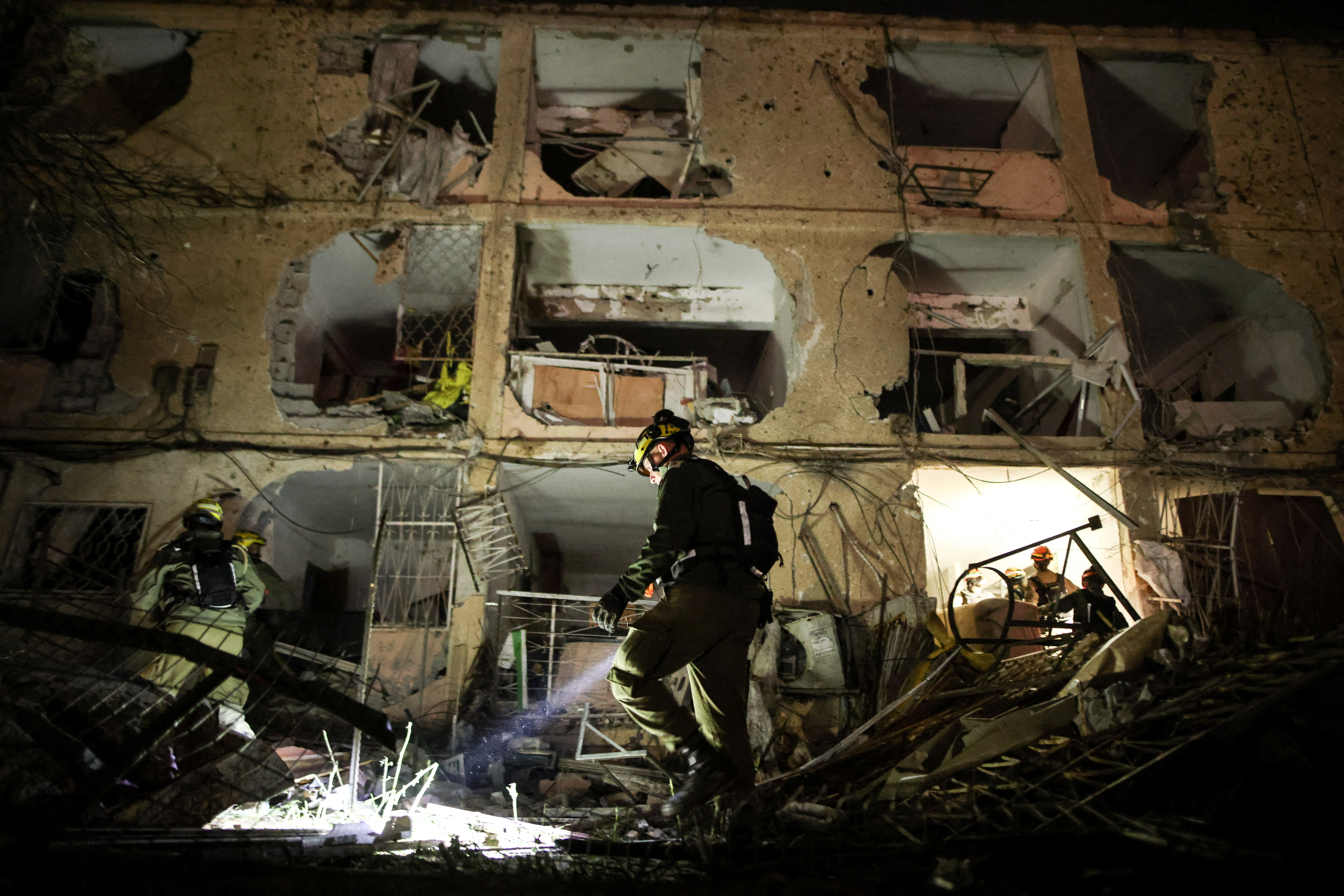 An Israeli soldier uses a torch to inspect the damage after Iranian missile barrages struck Dimona, amid the U.S.-Israel conflict with Iran, in southern Israel March 21, 2026.