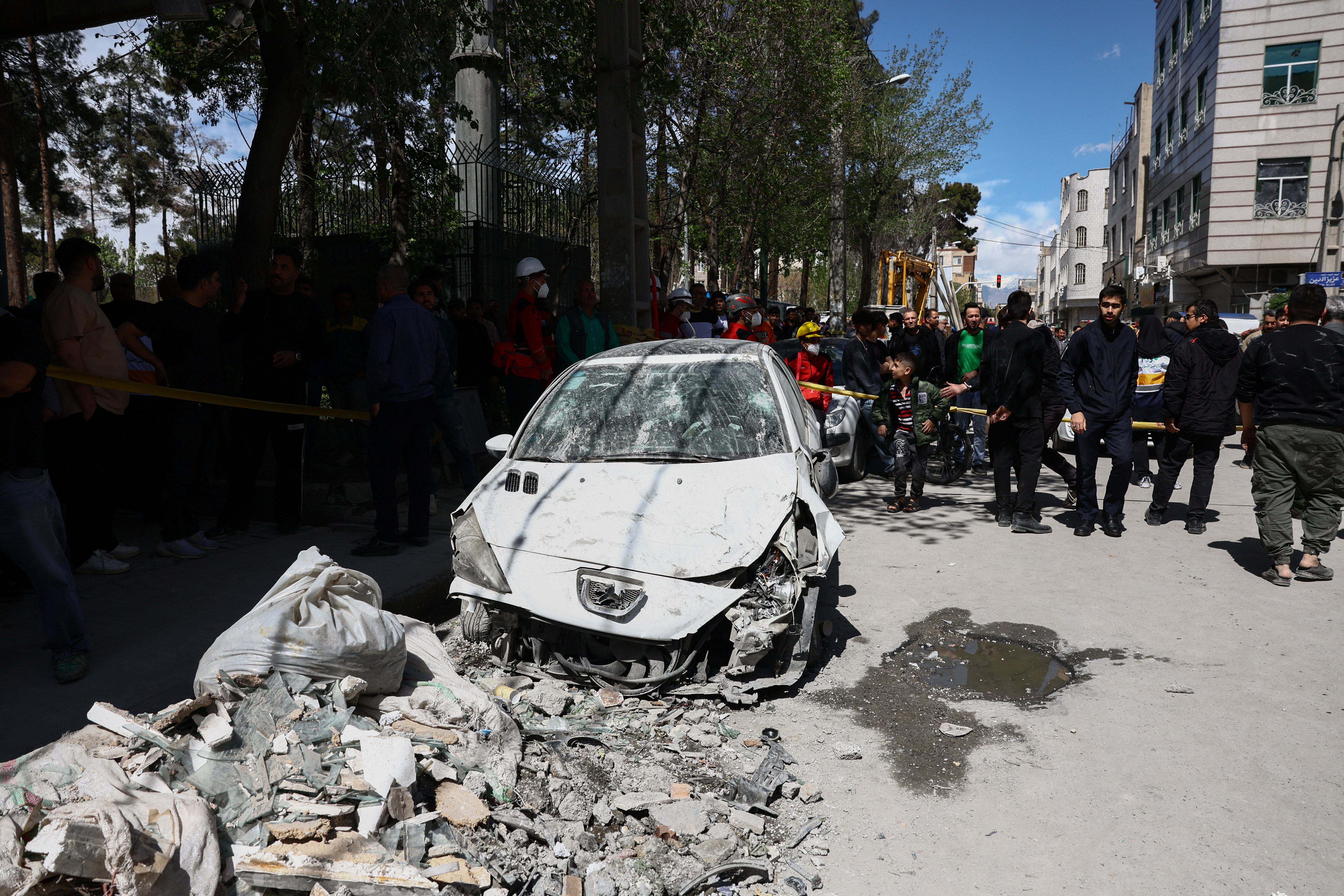 People gather near a damaged car at the site of a residential building damaged by a strike, amid the U.S.-Israeli conflict with Iran, in Tehran, Iran, March 27, 2026. Majid Asgaripour/WANA (West Asia News Agency) via REUTERS ATTENTION EDITORS - THIS PICTURE WAS PROVIDED BY A THIRD PARTY