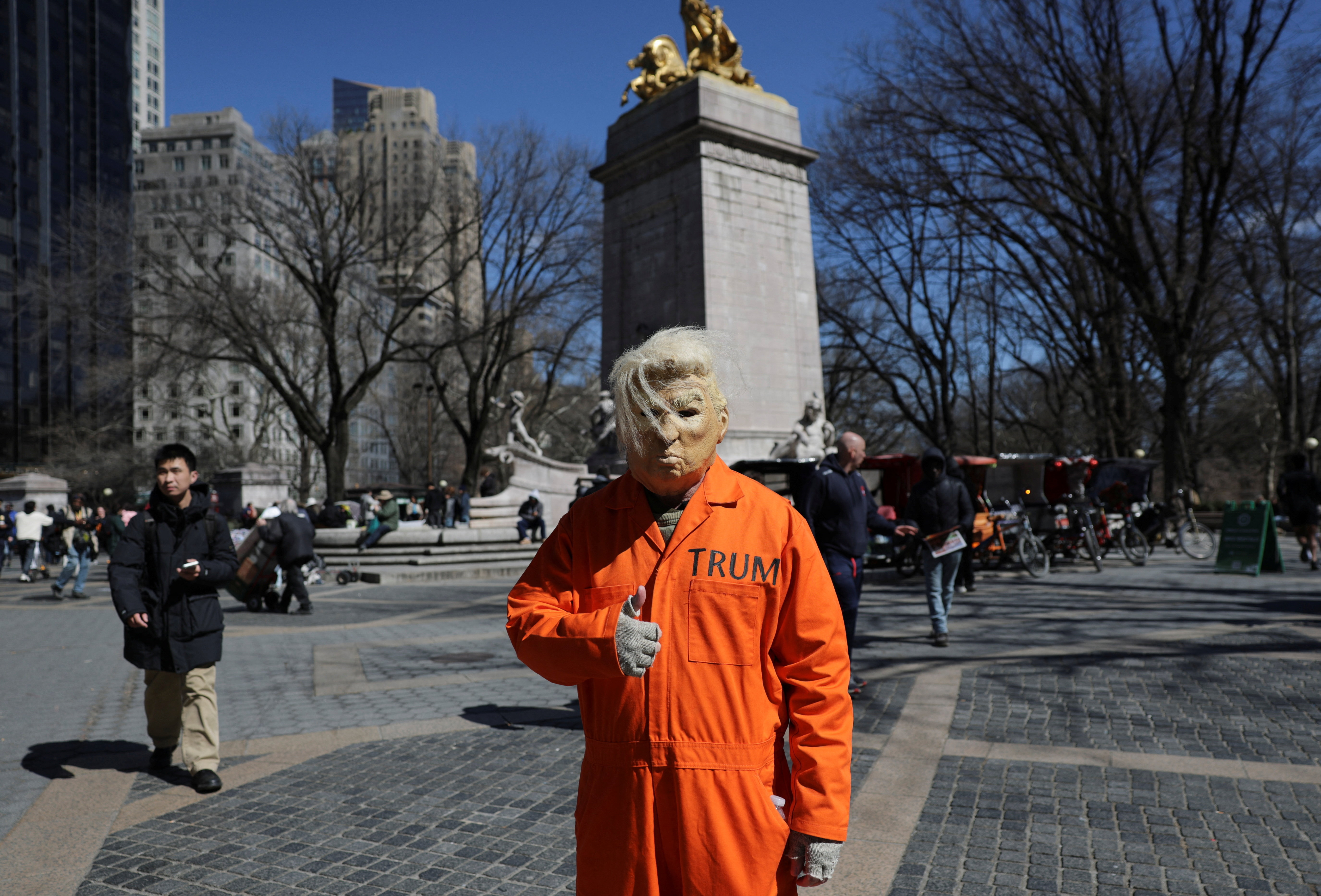 a protester disguised as Trump in an orange prison jumpsuit