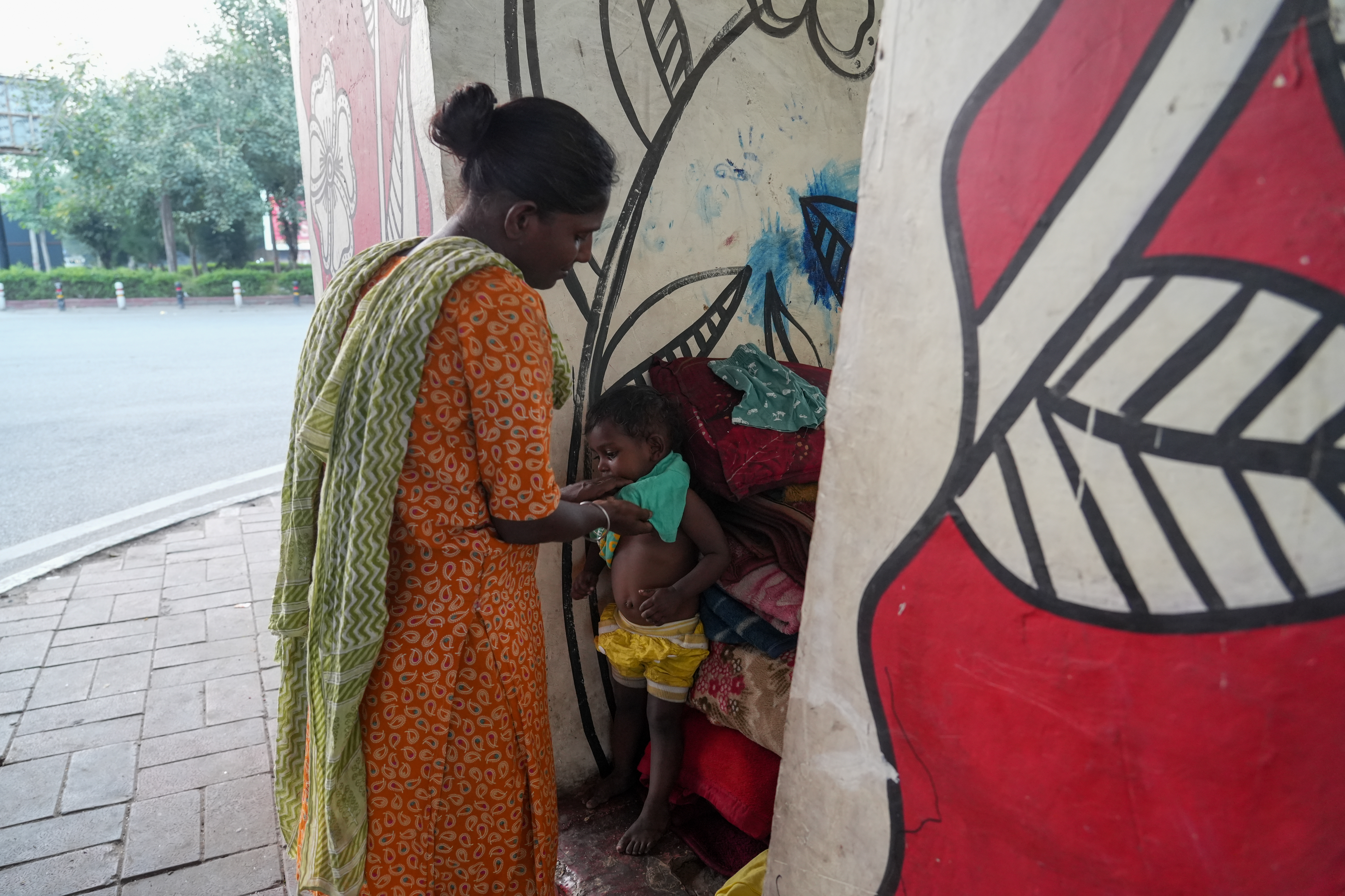 Abida changes her daughter Soni between the concrete walls beneath the flyover, the only space that offers a moment of privacy for breastfeeding or changing clothes.For a proper wash, she walks to a nearby public toilet, where she pays ₹10 each time.