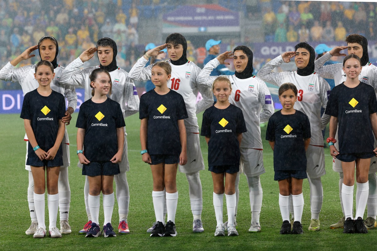 Iran's players salute during the national anthem before the AFC Women's Asian Cup Australia 2026 football match between Iran and Australia in Gold Coast on March 5, 2026. (Photo by Izhar KHAN / AFP) / -- IMAGE RESTRICTED TO EDITORIAL USE - STRICTLY NO COMMERCIAL USE --