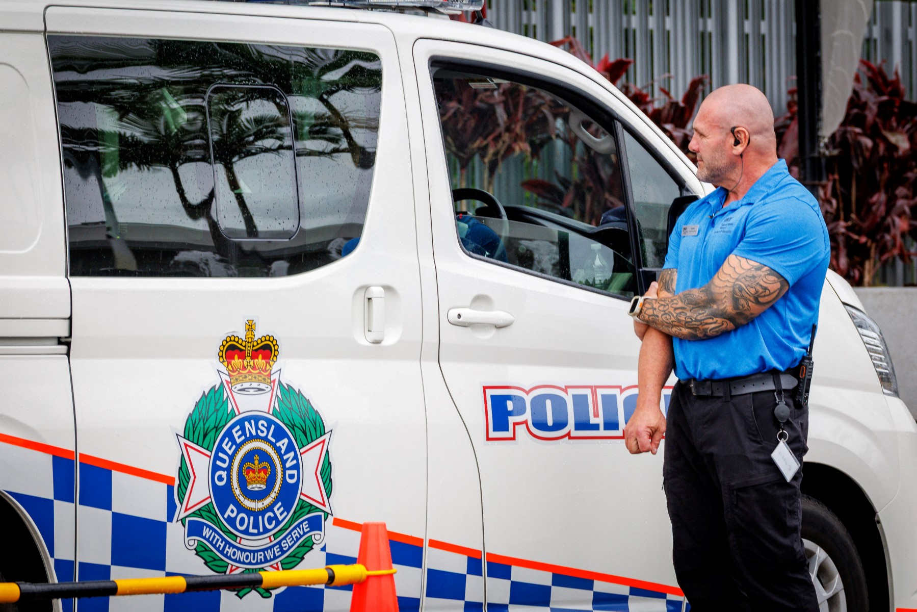A hotel security member stands beside a police van at the entrance to the Royal Pines Resort, where members of the Iranian womens football team are staying, on the Gold Coast on March 9, 2026. Australia must protect the visiting Iranian women's football team, the son of the nation's late shah urged March 9, warning their refusal to sing the national anthem before a match could have "dire consequences". (Photo by Patrick HAMILTON / AFP)