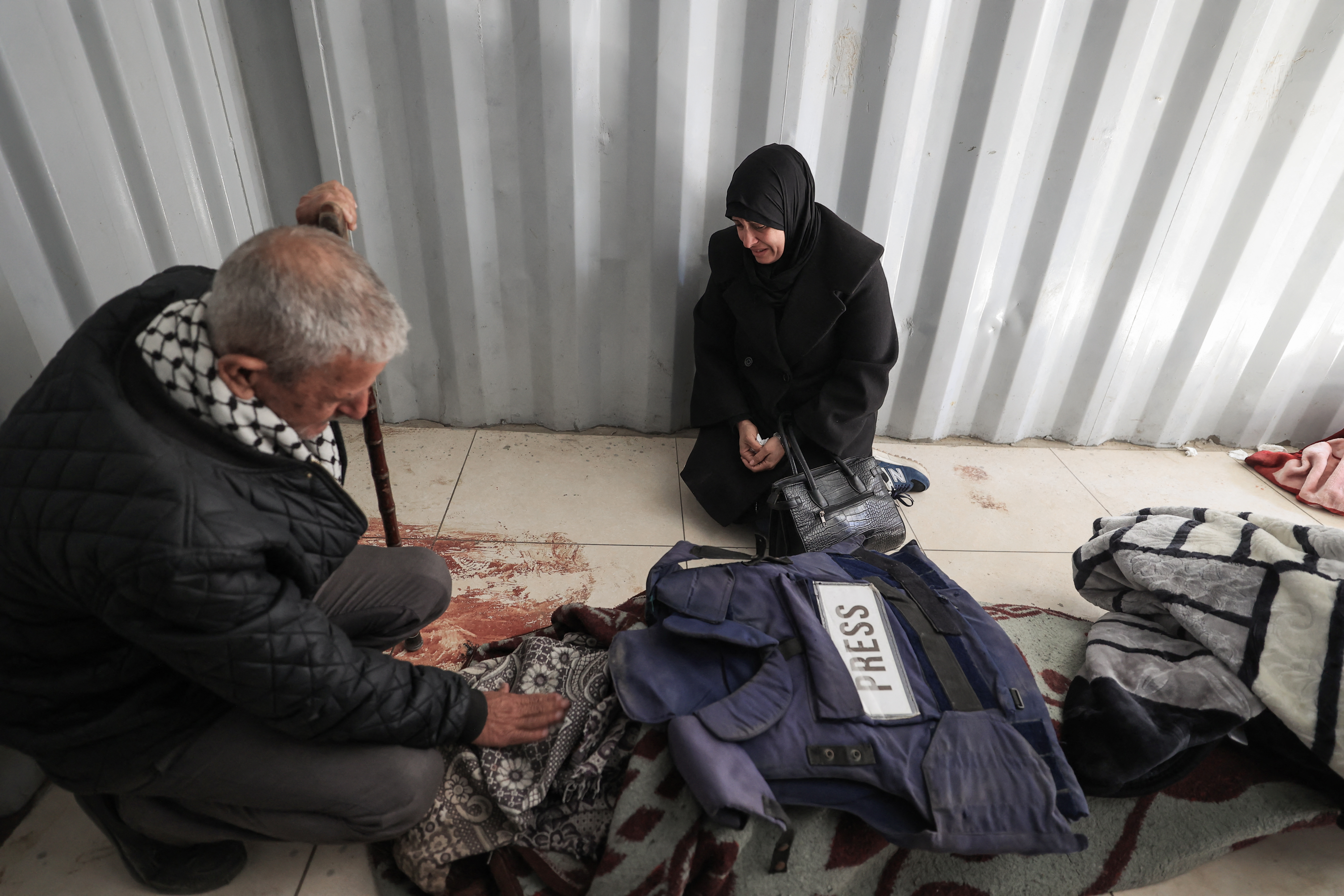 Relatives mourn over the body of journalist Amal al-Shamali, reportedly killed in an overnight Israeli strike, at al-Awda Hospital in the Nuseirat refugee camp, central Gaza Strip, on March 9, 2026.