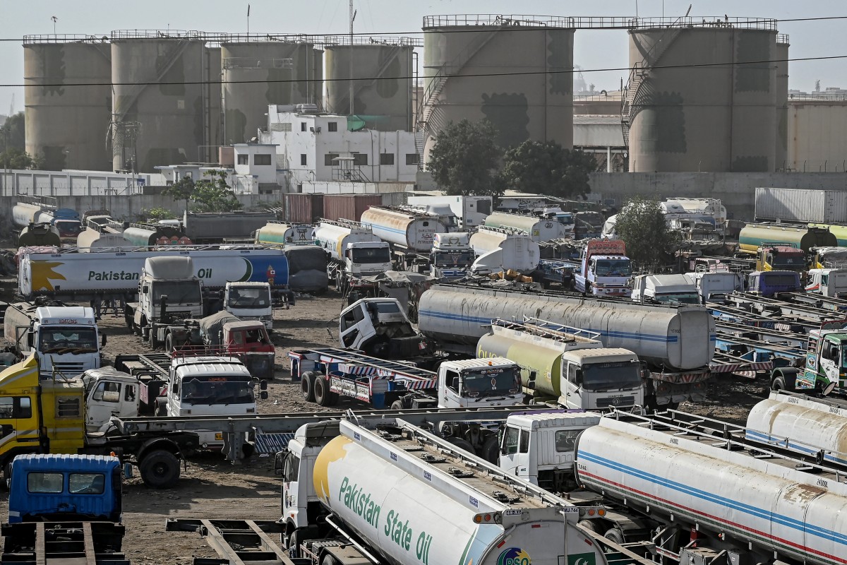 Oil tankers stand parked near an oil storage terminal in Karachi on March 12, 2026 as global energy markets face disruptions amid the ongoing conflict in the Middle East. Tanker drivers in Pakistan said they were facing long waits at depots due to fuel shortages