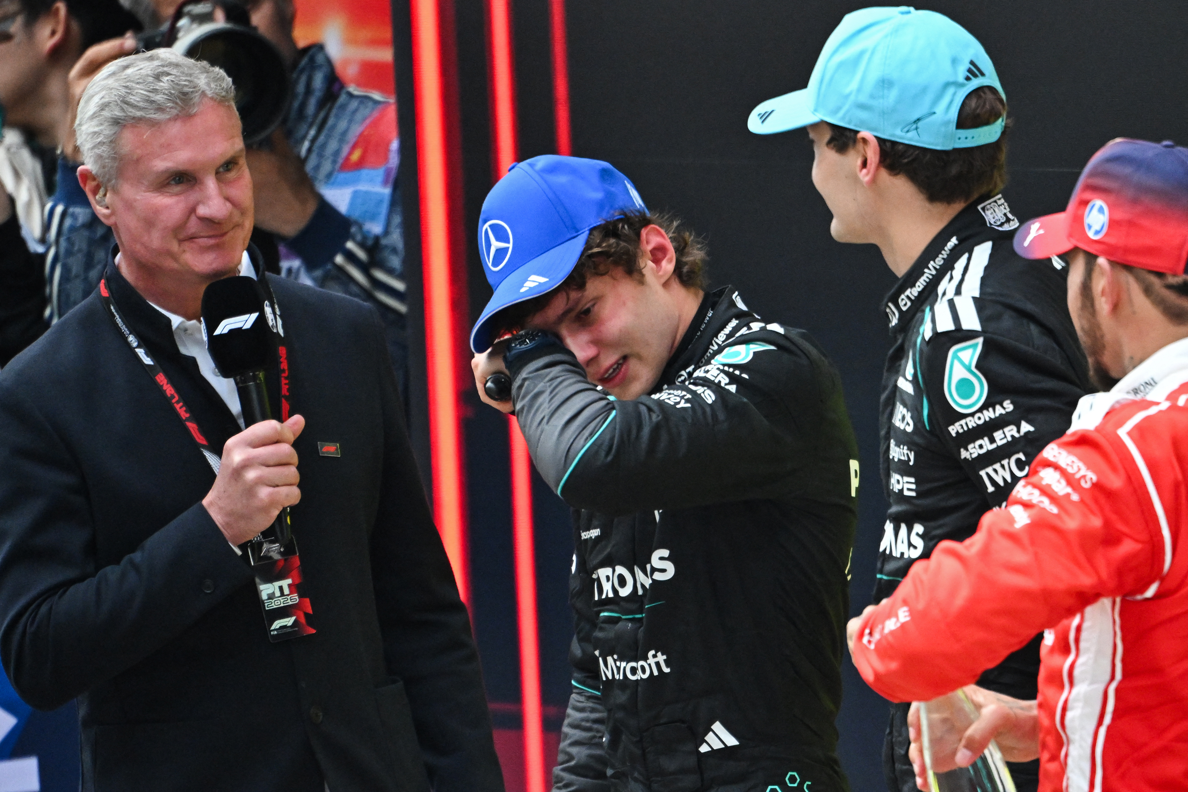 First-placed Mercedes' Italian driver Kimi Antonelli (2L) celebrates winning alongside Mercedes' British driver George Russell (2R) and Ferrari's British driver Lewis Hamilton (R) after the Formula One Chinese Grand Prix at the Shanghai International Circuit in Shanghai on March 15, 2026. (Photo by JADE GAO / AFP)