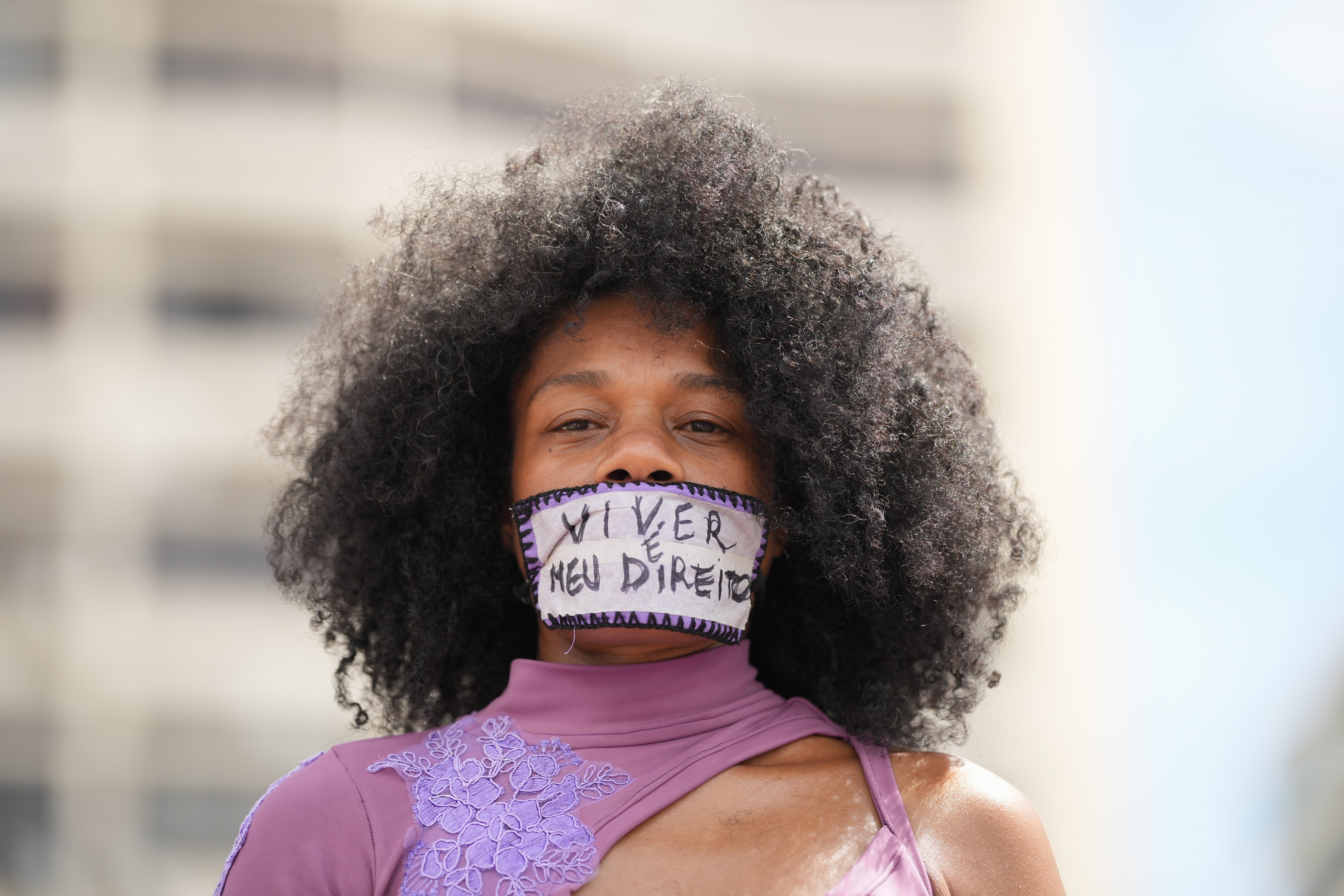 A woman with tape reading ‘living is my right’ over her mouth takes part in a march marking International Women’s Day on Copacabana beach in Rio de Janeiro, on March 8, 2026