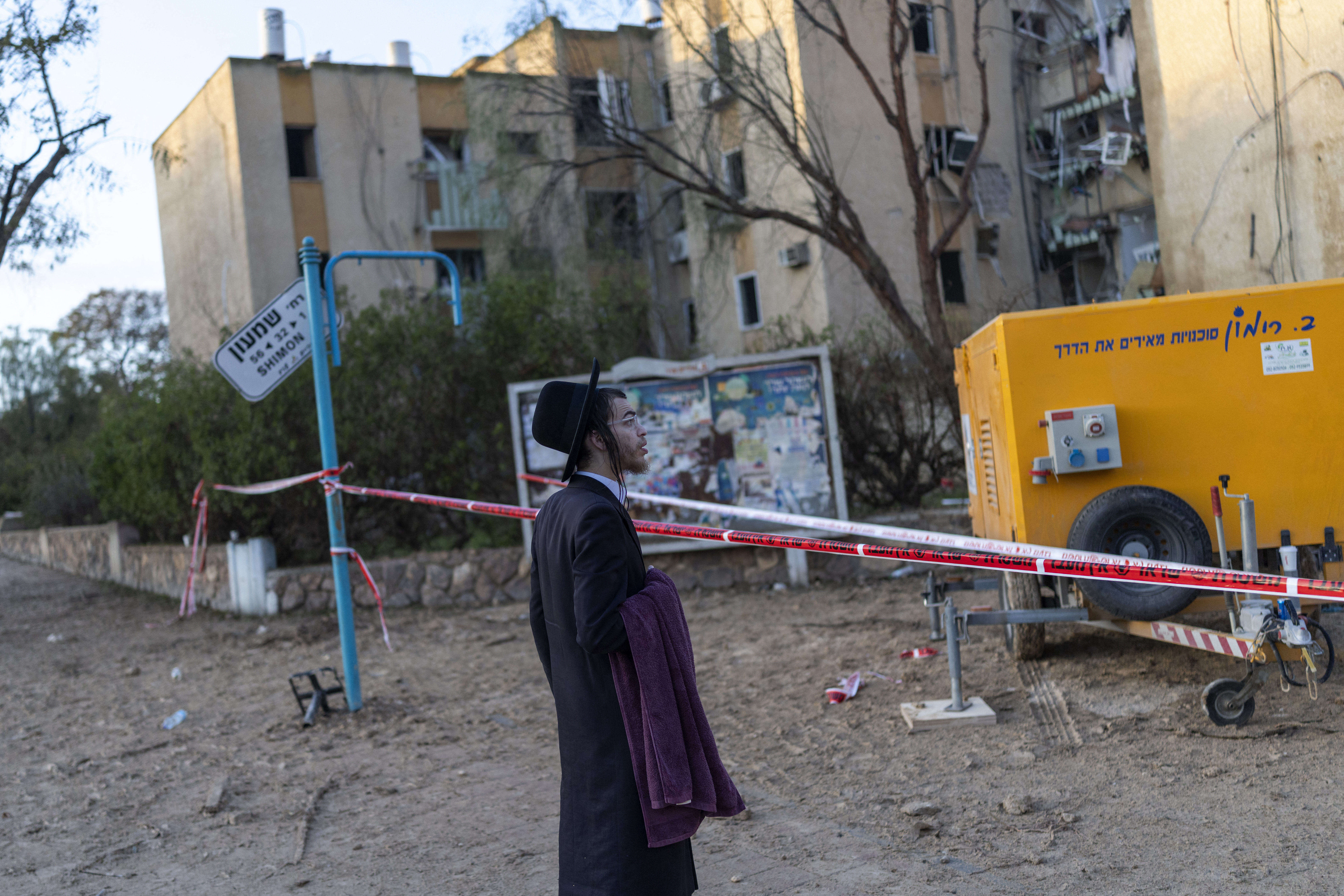 An Israeli Orthodox Jew inspects the site of an Iranian missile strike in Arad on March 22, 2026.