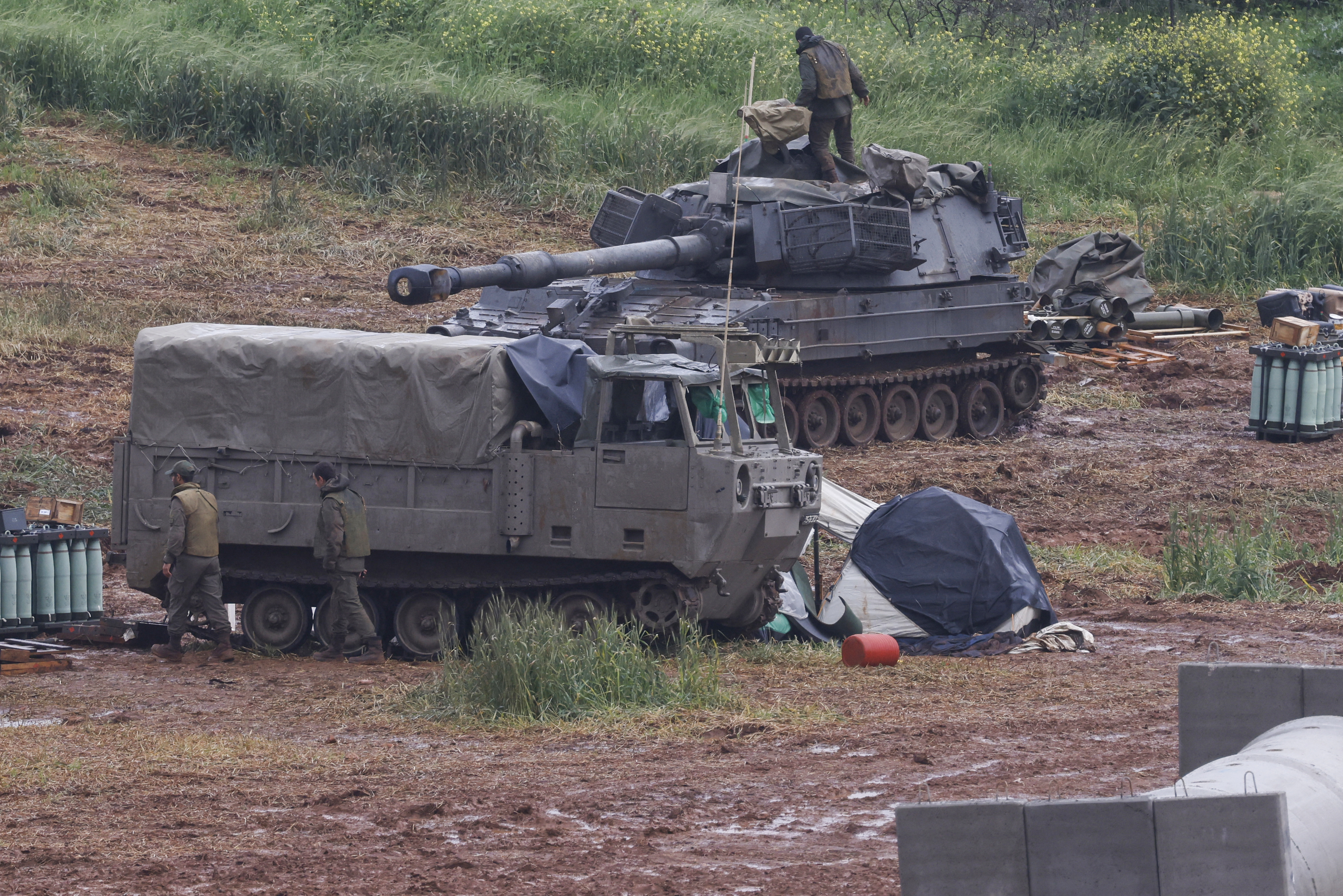 An Israeli soldier stands on a self-propelled Howitzer artillery gun
