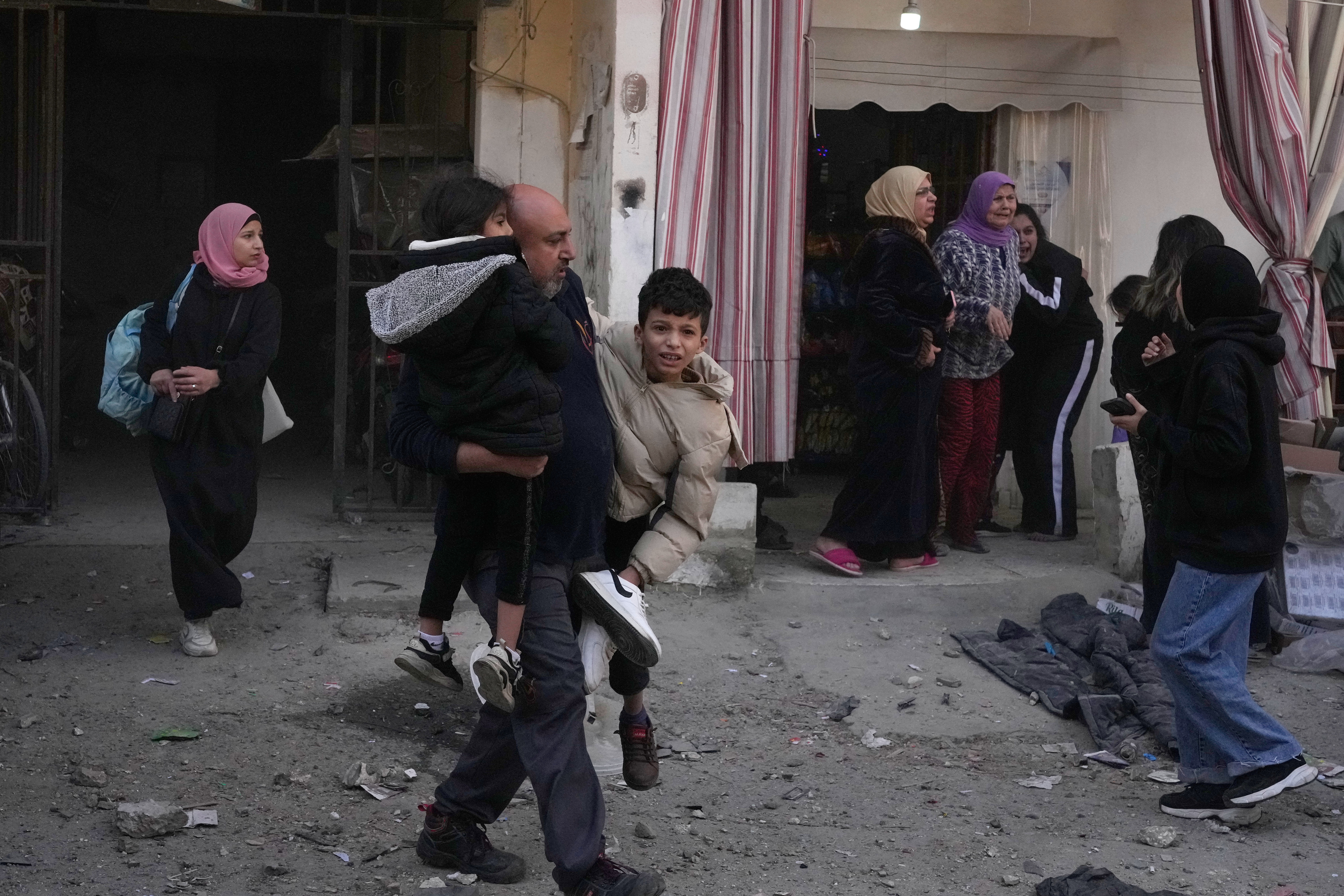 Residents flee the site of an Israeli airstrike that hit an apartment building in the southern port city of Sidon, Lebanon, Friday, March 13, 2026. (AP Photo/Mohammed Zaatari)