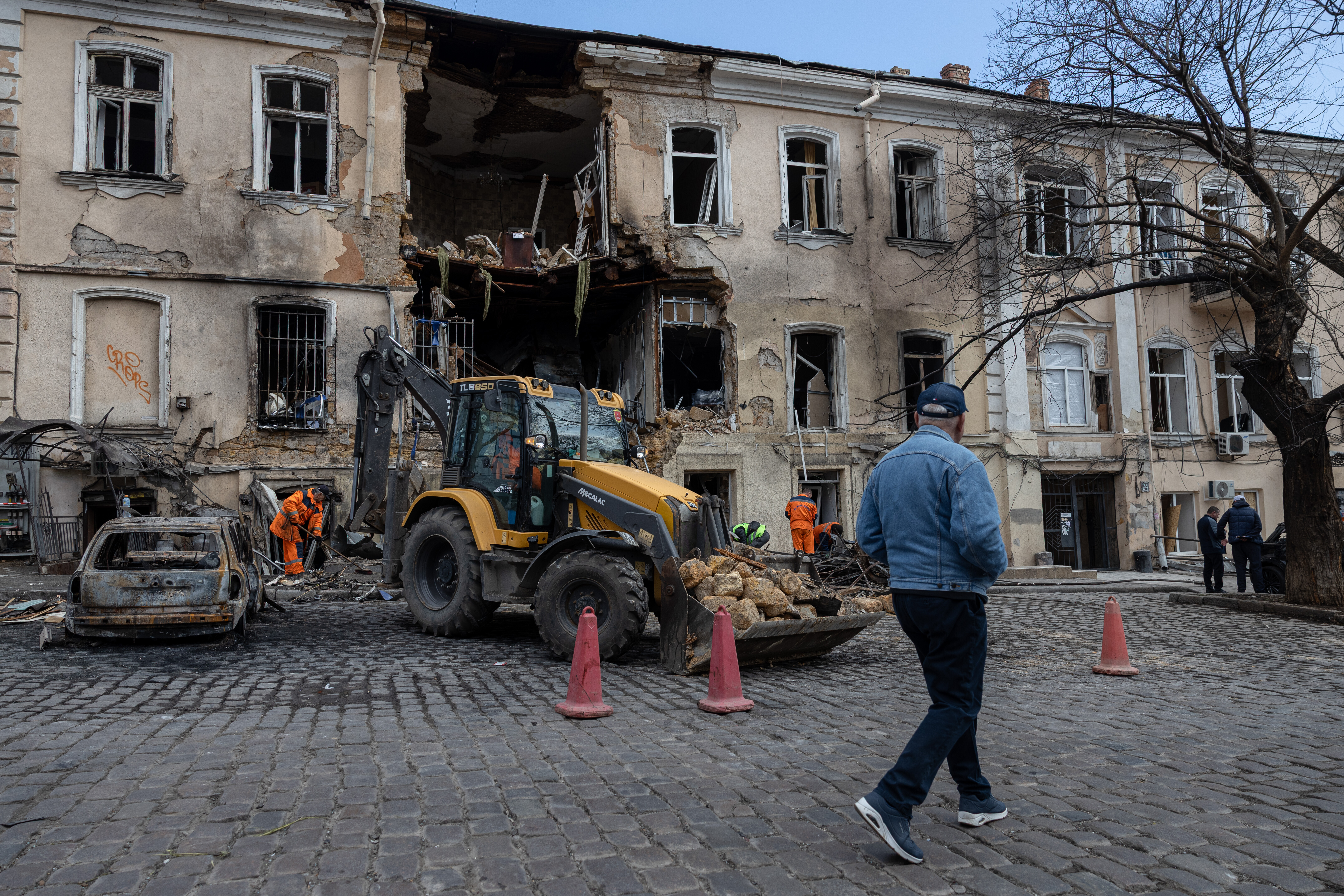 Municipal workers clear the rubble from a residential building damaged after a Russian drone attack in Odesa
