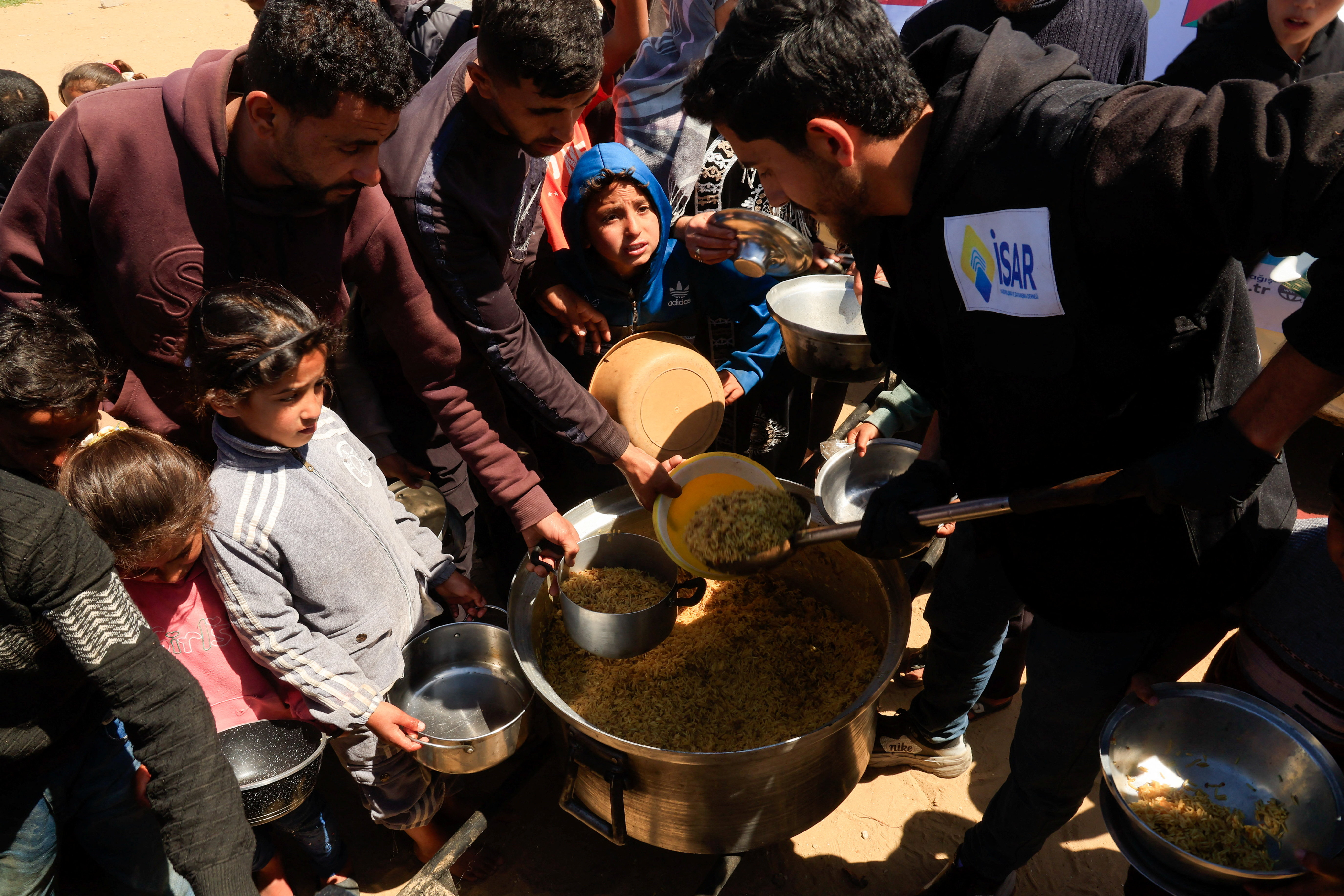 Palestinians gather to receive food from a charity kitchen.