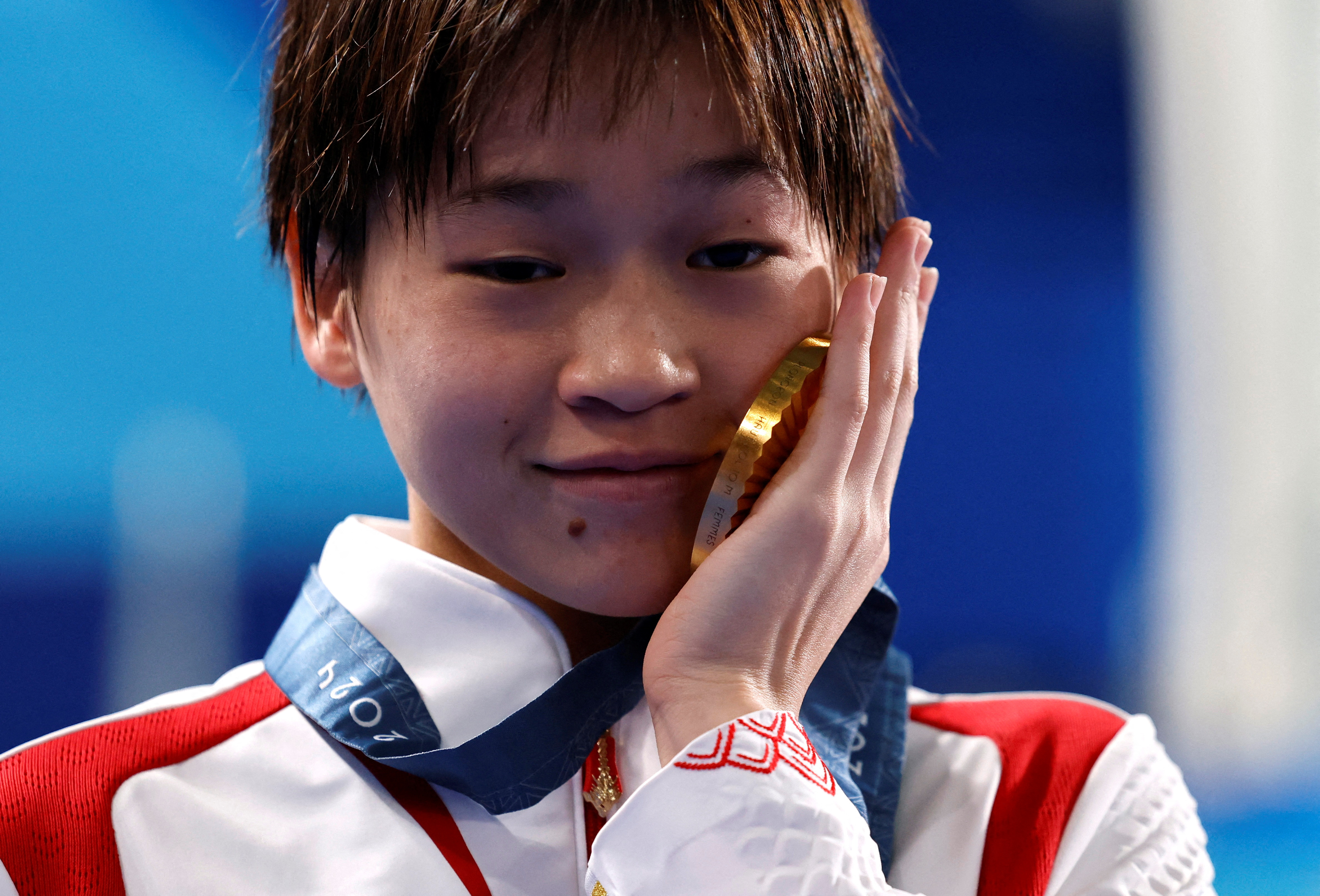 FILE PHOTO: Paris 2024 Olympics - Diving - Women's 10m Platform Victory Ceremony - Aquatics Centre, Saint-Denis, France - August 06, 2024. Gold medallist Hongchan Quan of China celebrates with her medal on the podium. REUTERS/Lisa Leutner/File Photo