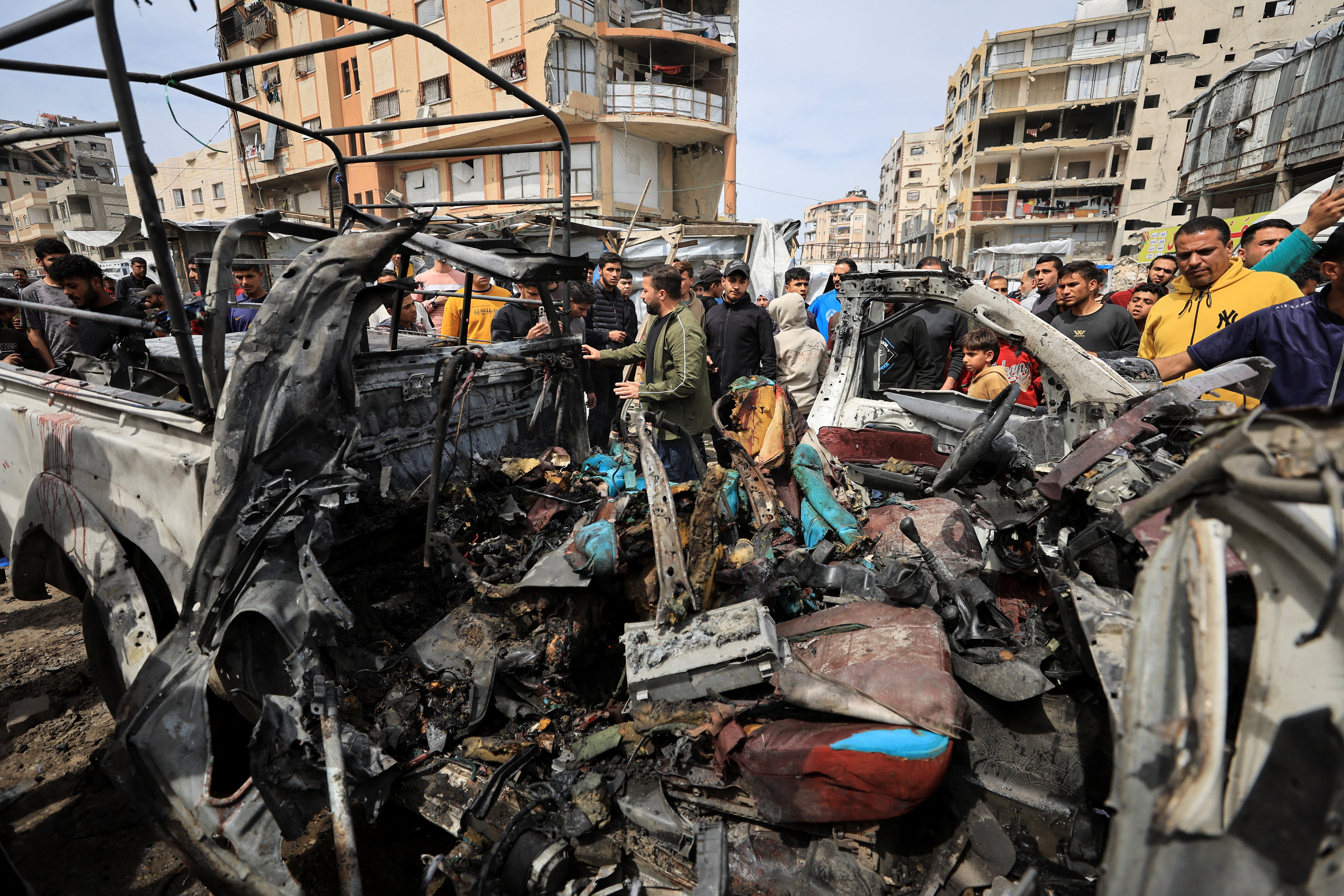 Palestinians inspect the damage after an Israeli strike targeted a police vehicle in Gaza City, according to medics, in Gaza City, April 14, 2026. REUTERS/Dawoud Abu Alkas