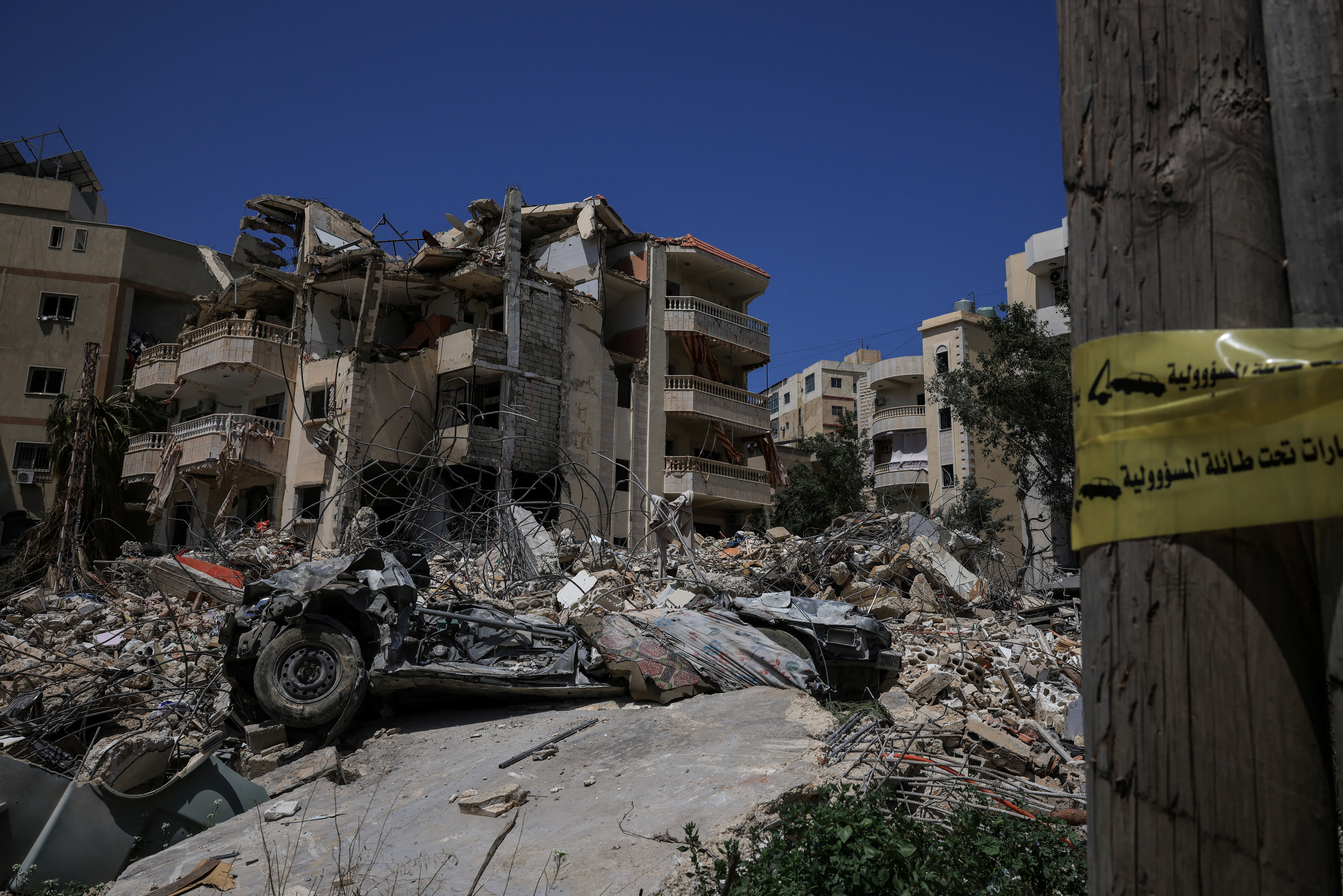 A civil defence ambulance drives by the rubble of buildings