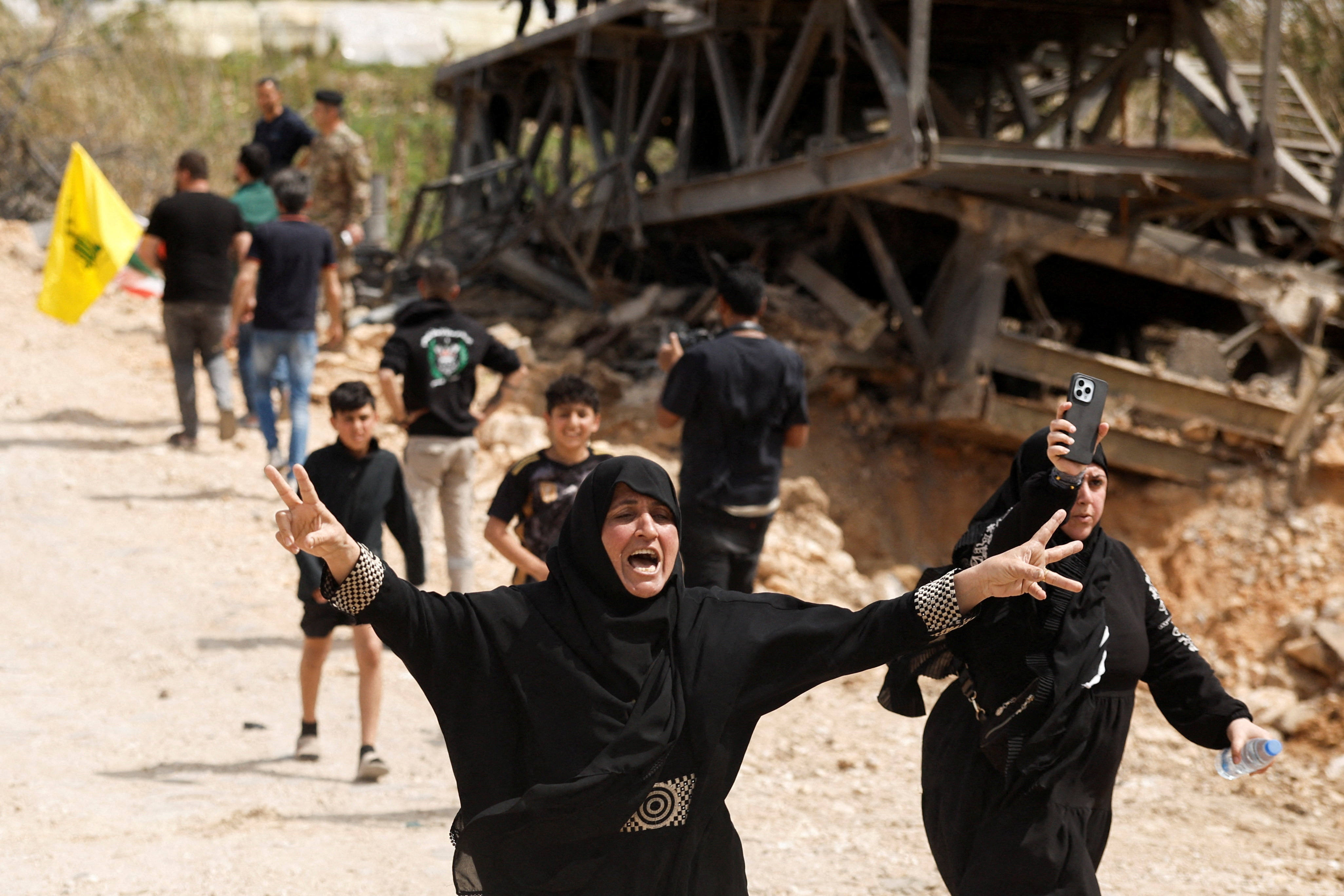 Women react as displaced people make their way back to their homes crossing the bridge linking southern Lebanon to the rest of the country, which was hit earlier in an Israeli strike, after a 10-day ceasefire between Lebanon and Israel went into effect, in Qasmiyeh, Lebanon, April 17, 2026. REUTERS/Louisa Gouliamaki TPX IMAGES OF THE DAY