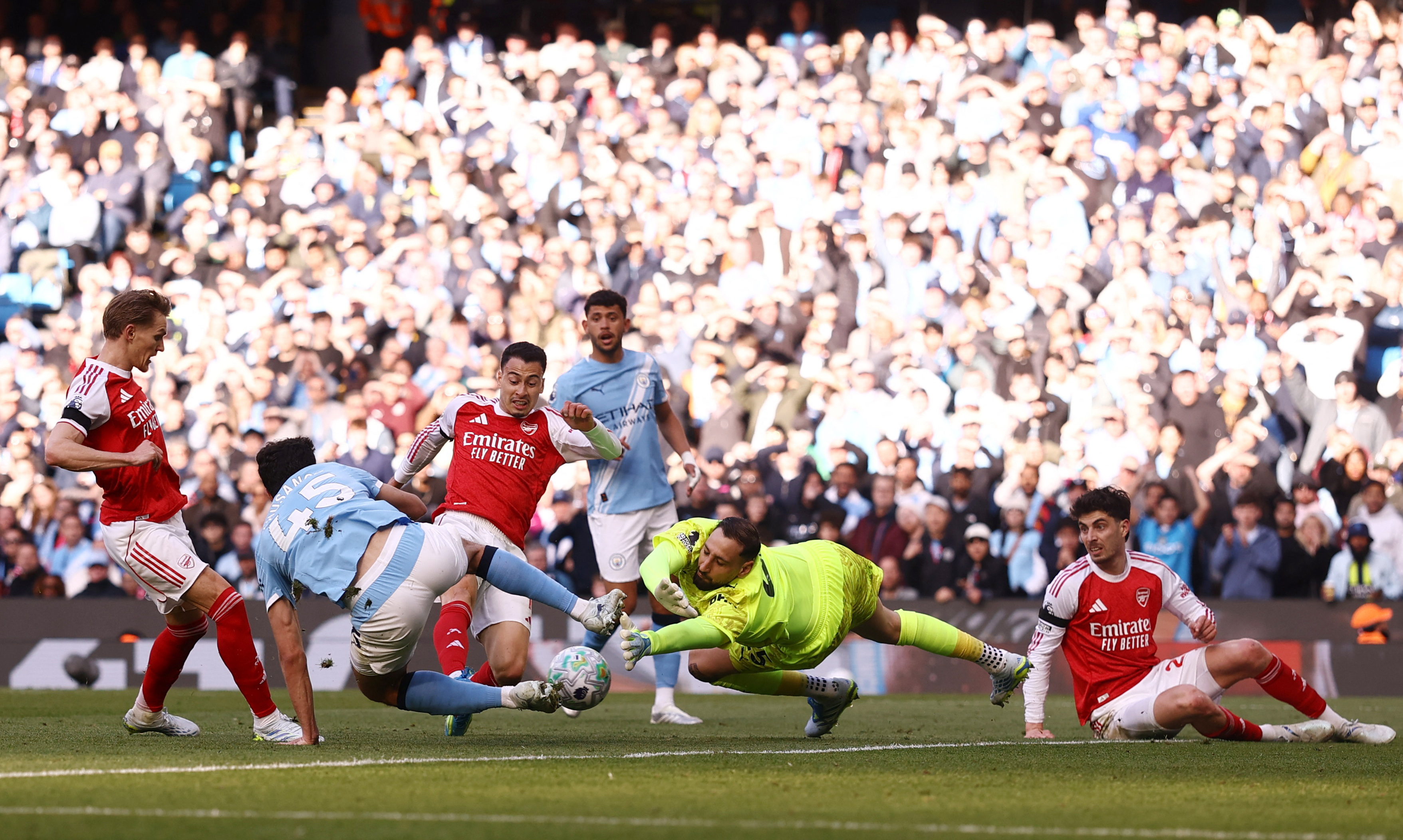 Soccer Football - Premier League - Manchester City v Arsenal - Etihad Stadium, Manchester, Britain - April 19, 2026 Arsenal's Gabriel Martinelli in action with Manchester City's Abdukodir Khusanov and Gianluigi Donnarumma Action Images via Reuters/Lee Smith EDITORIAL USE ONLY. NO USE WITH UNAUTHORIZED AUDIO, VIDEO, DATA, FIXTURE LISTS, CLUB/LEAGUE LOGOS OR 'LIVE' SERVICES. ONLINE IN-MATCH USE LIMITED TO 120 IMAGES, NO VIDEO EMULATION. NO USE IN BETTING, GAMES OR SINGLE CLUB/LEAGUE/PLAYER PUBLICATIONS. PLEASE CONTACT YOUR ACCOUNT REPRESENTATIVE FOR FURTHER DETAILS..