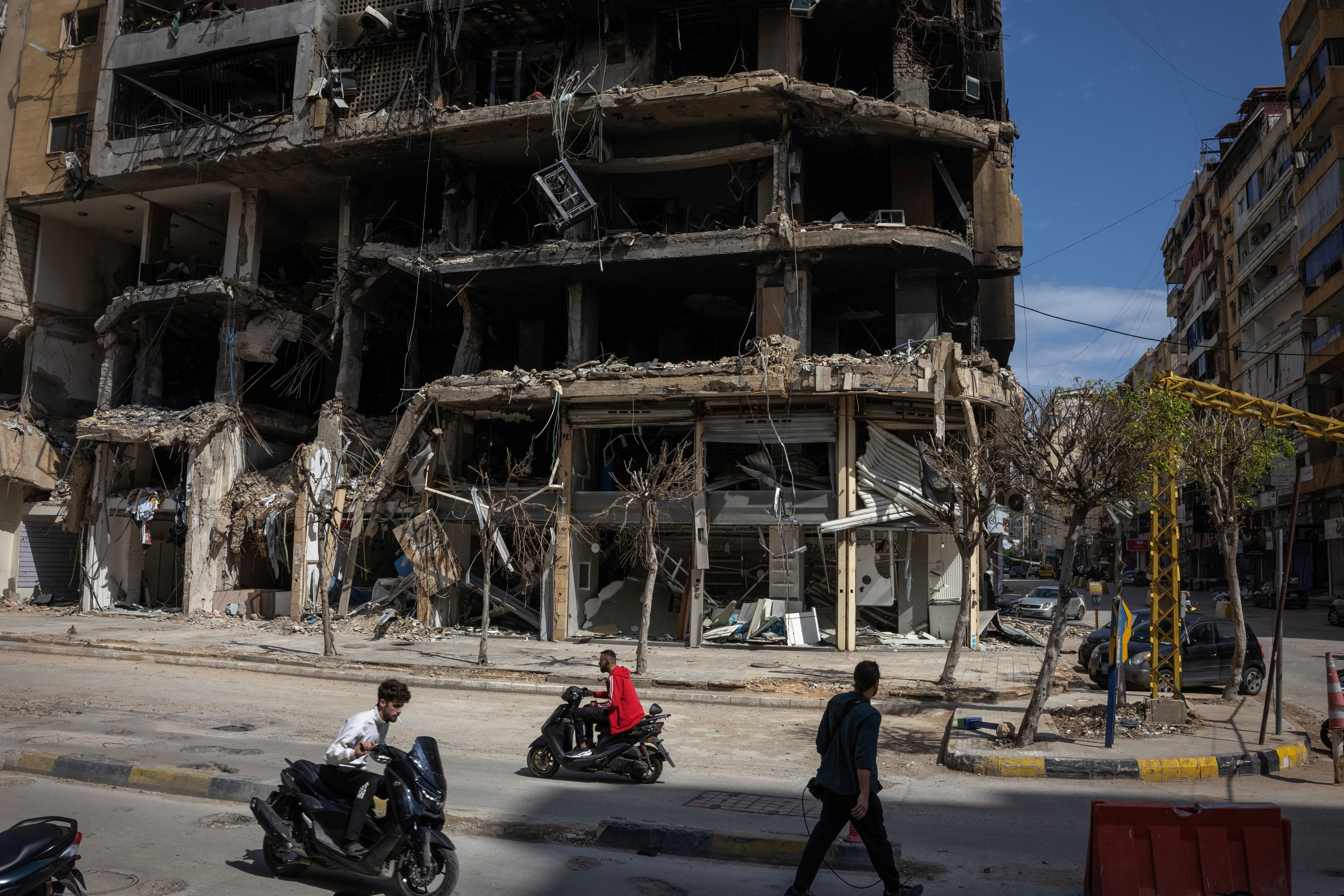People pass damaged buildings in Beirut.
