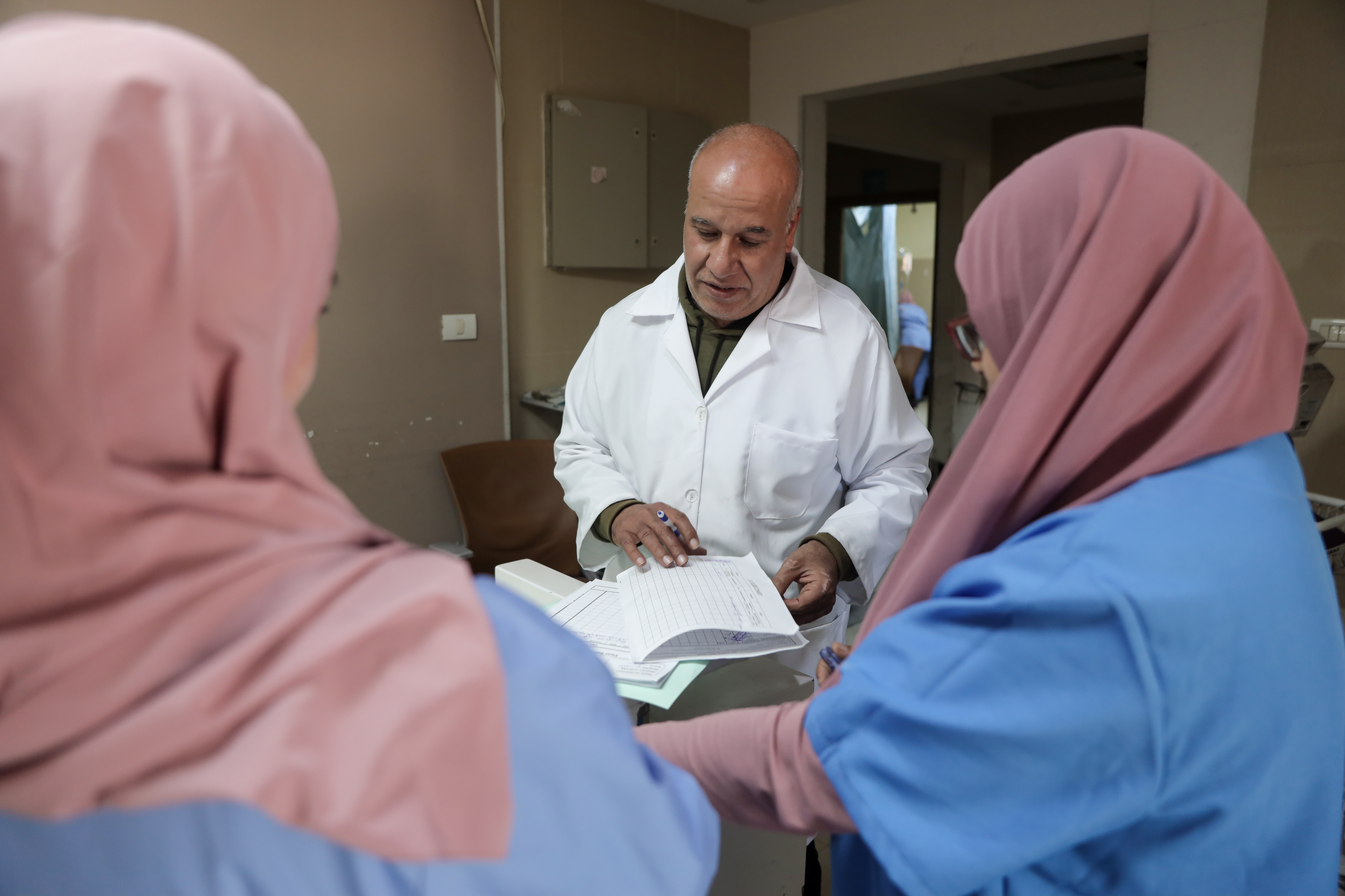 Dr Fathi al-Dahdouh talks to two nurses
