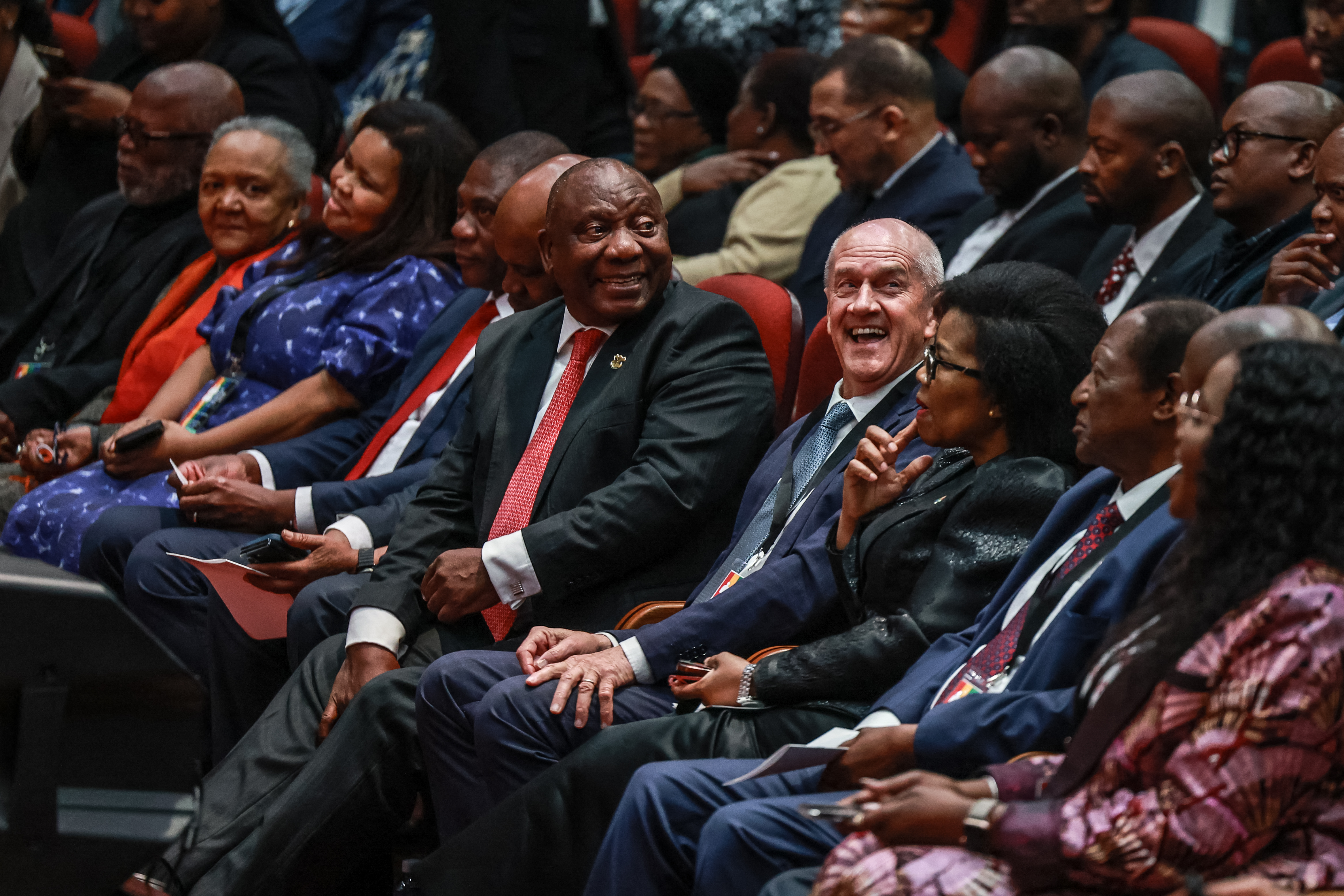 South African President Cyril Ramaphosa (CL) and Former Minister and constitutional negotiator Roelf Meyer (CR) looks at attendees during the first National Convention at the University of South Africa (UNISA) in Pretoria on August 15, 2025. The first National Convention marks the start of the National Dialogue (a chance where all South Africans come together to discuss the country's challenges) at local meetings, national discussions and public platforms aimed at shaping a better future for the next thirty years. (Photo by Phill Magakoe / AFP)