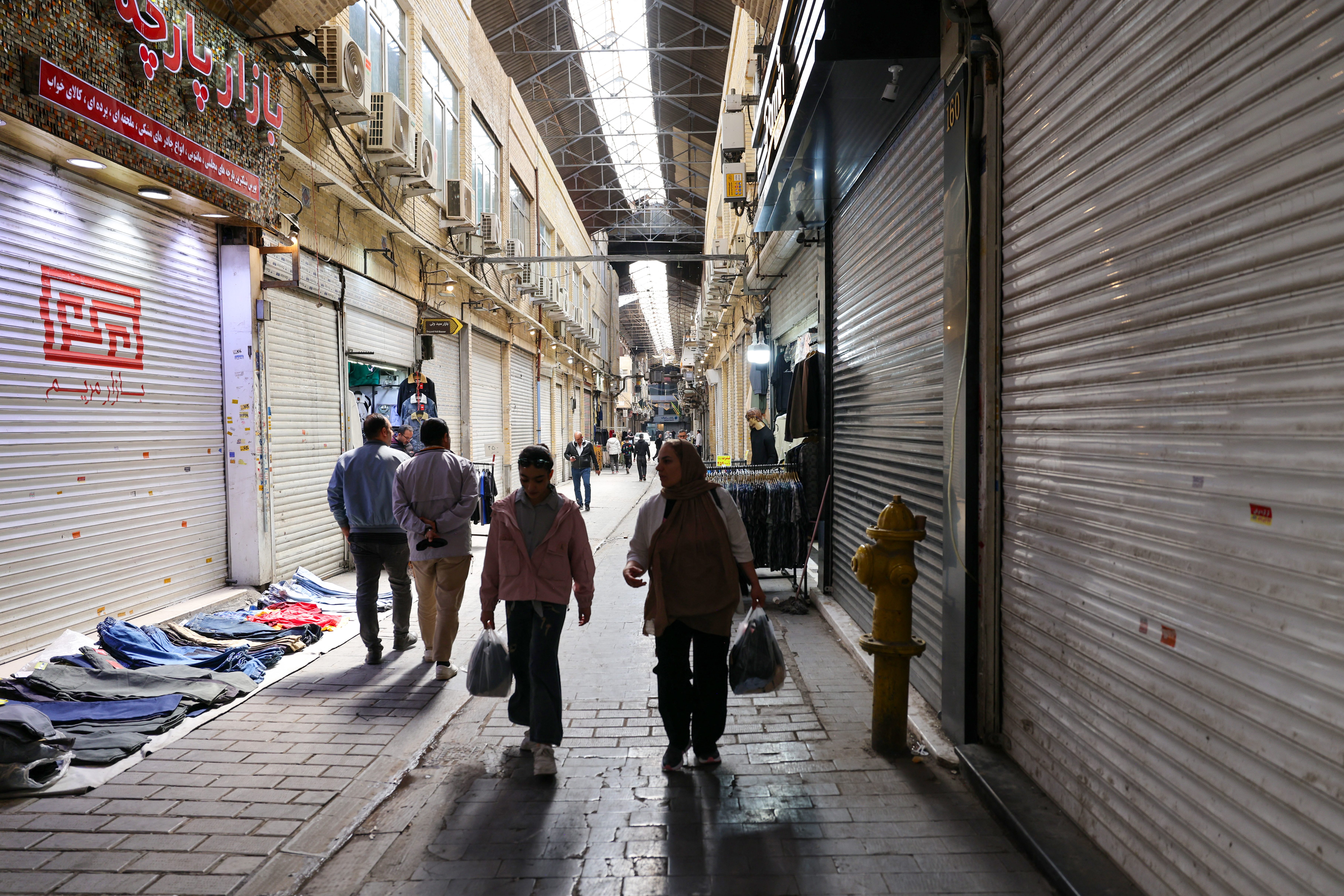 People walk past closed shops at the Grand Bazaar in Tehran, Iran on March 30, 2026.