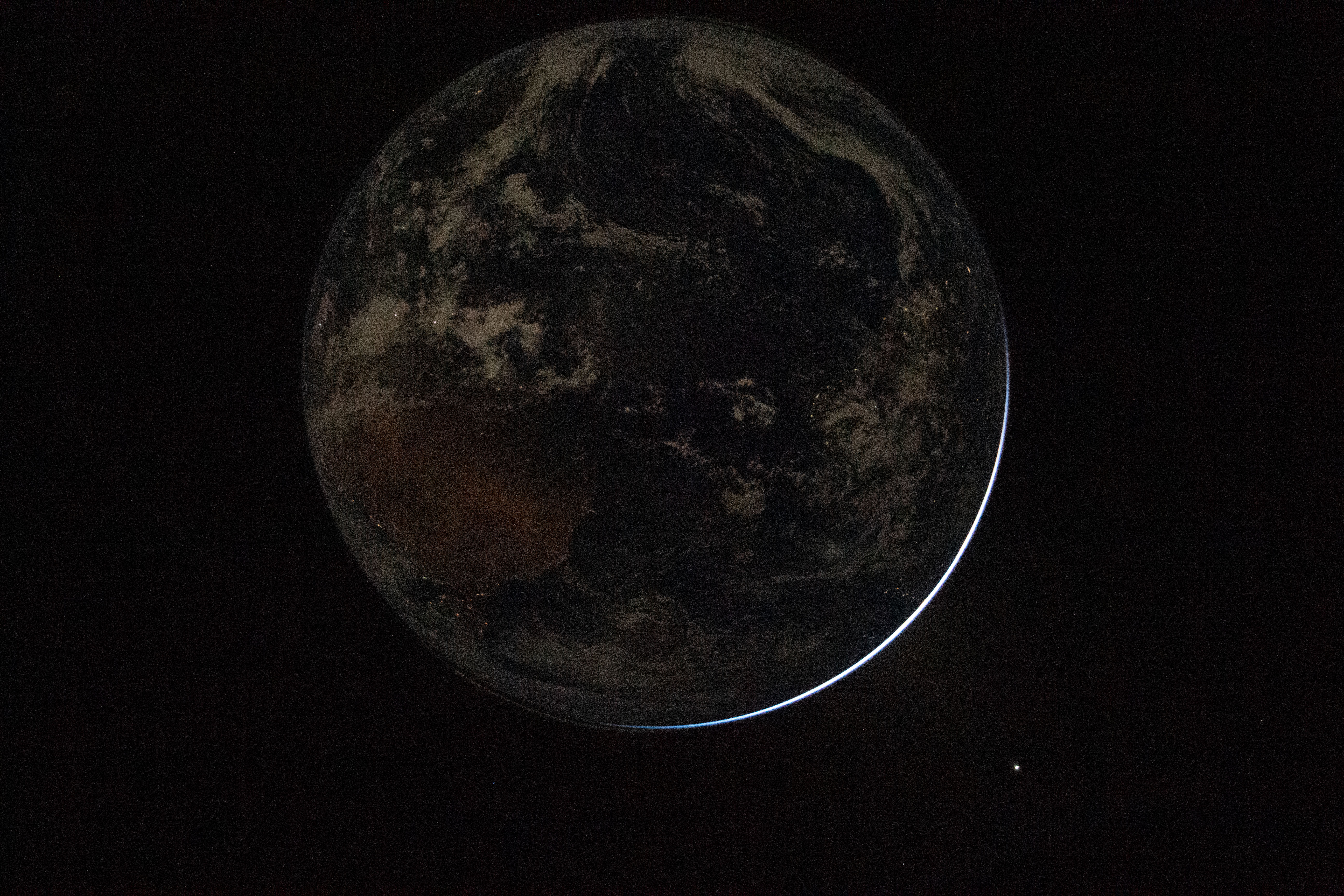 This handout picture provided by NASA shows a view of a backlit Earth as seen through the Orion spacecrafts window
