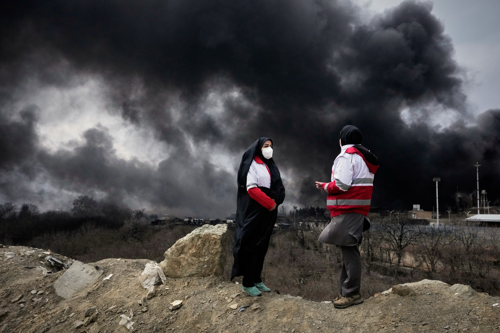 women stand by black smoke