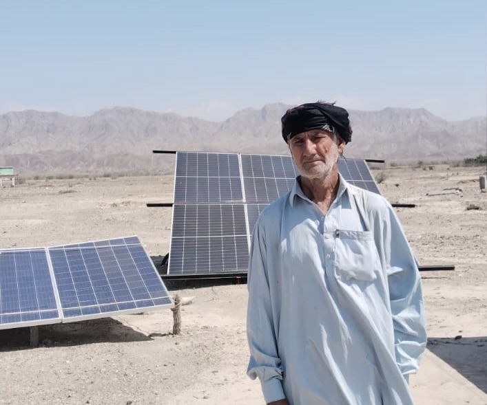 Karim Baksh stands beside solar panels used to irrigate his watermelons in Dasht,district Kech, Balochistan, Pakistan