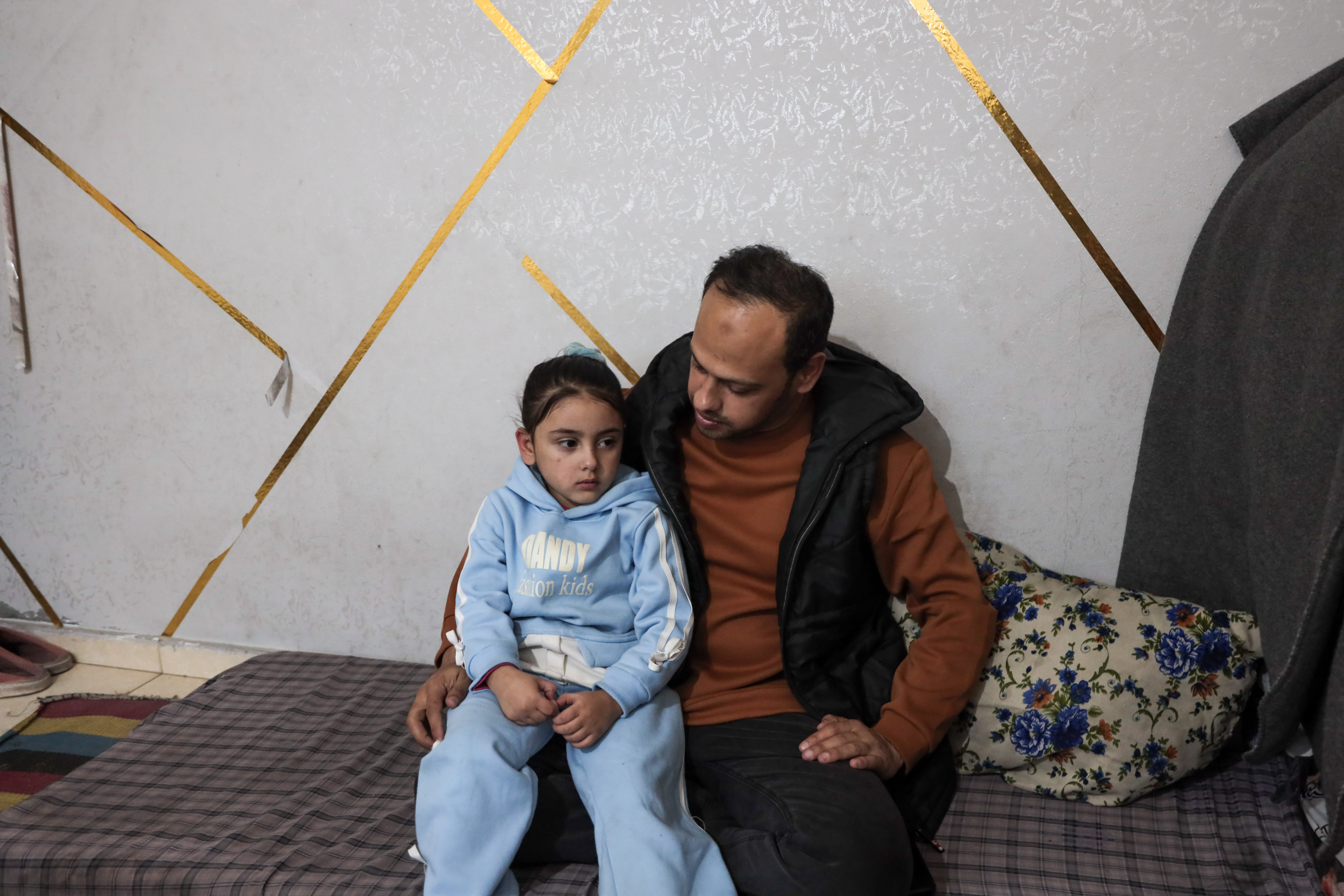 Mohammed with his only surviving daughter, Jana, 4, the sole remaining member of his immediate family [Abdelhakim Abu Riash/ Al Jazeera]