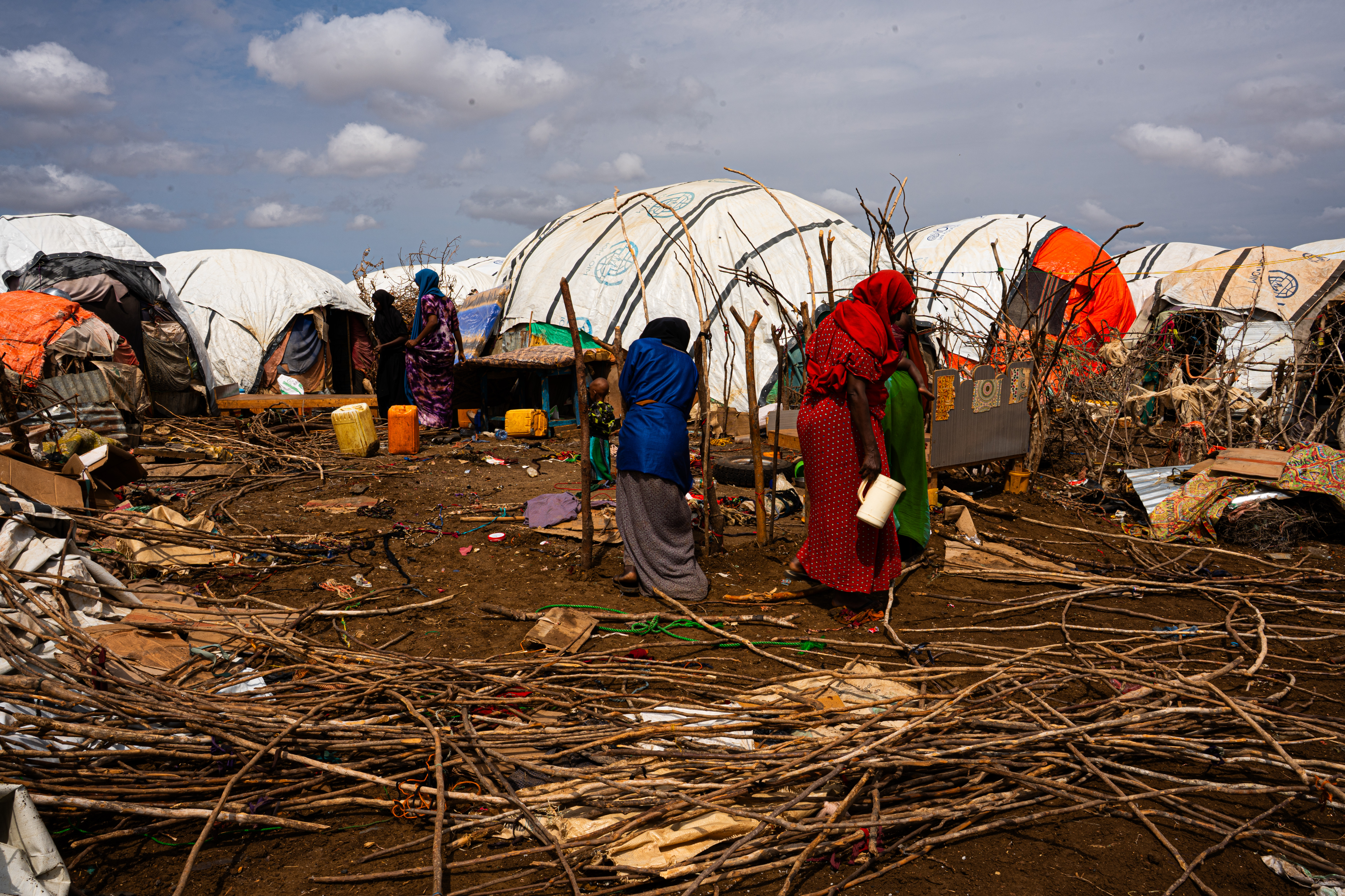Newly arrived families at Wayamo displacement camp construct temporary shelters from plastic sheets, sticks, and scraps of cloth. The structures offer minimal protection from the intense heat and provide almost no privacy or safety. Qaydar-adde camp in Baidoa is one of the main destinations for families fleeing drought from the Bay and Bakool regions, but the growing number of arrivals has pushed already limited resources to breaking point. Access to safe water, sanitation, and healthcare is critically inadequate. Wayamo displacement camp, Baidoa, Southwest State, Somalia. [Abdulkadir Mohamed/NRC]