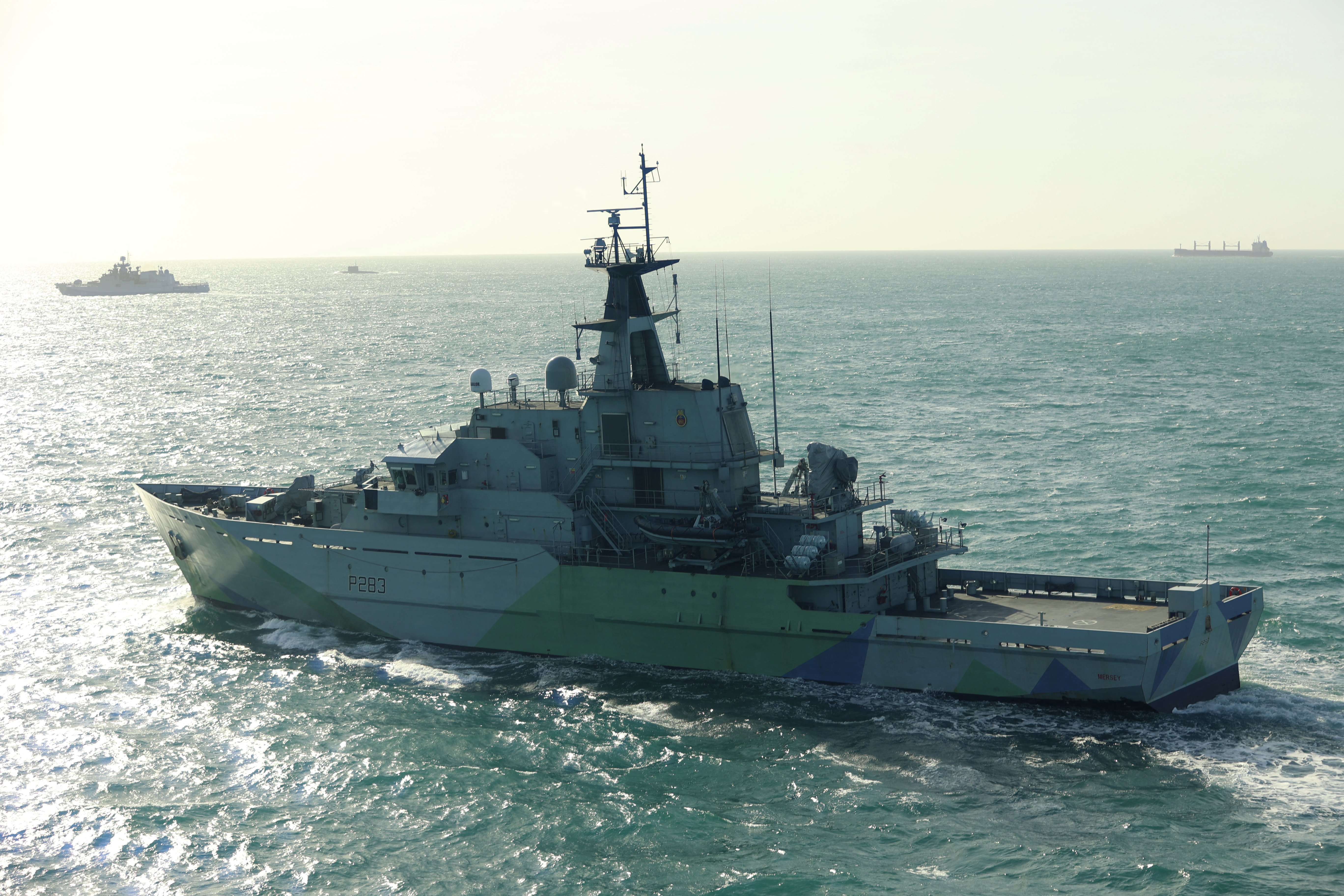 This undated handout image release on April 9, 2026 by Britain's Royal Navy shows the HMS Mersey (foreground) tracking Russian frigate Admiral Grigorovich (far L) and Kilo-class submarine Krasnodar (2nd L-in distance) in UK waters at sea.