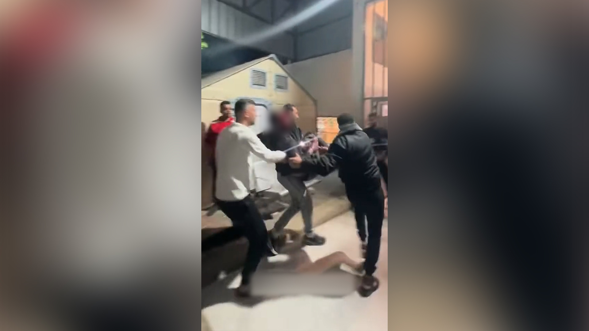 Men rush a victim of an Israeli strike on Gaza's Shati refugee camp to a medical facility on April 14, 2026. [Screenshot via social media]