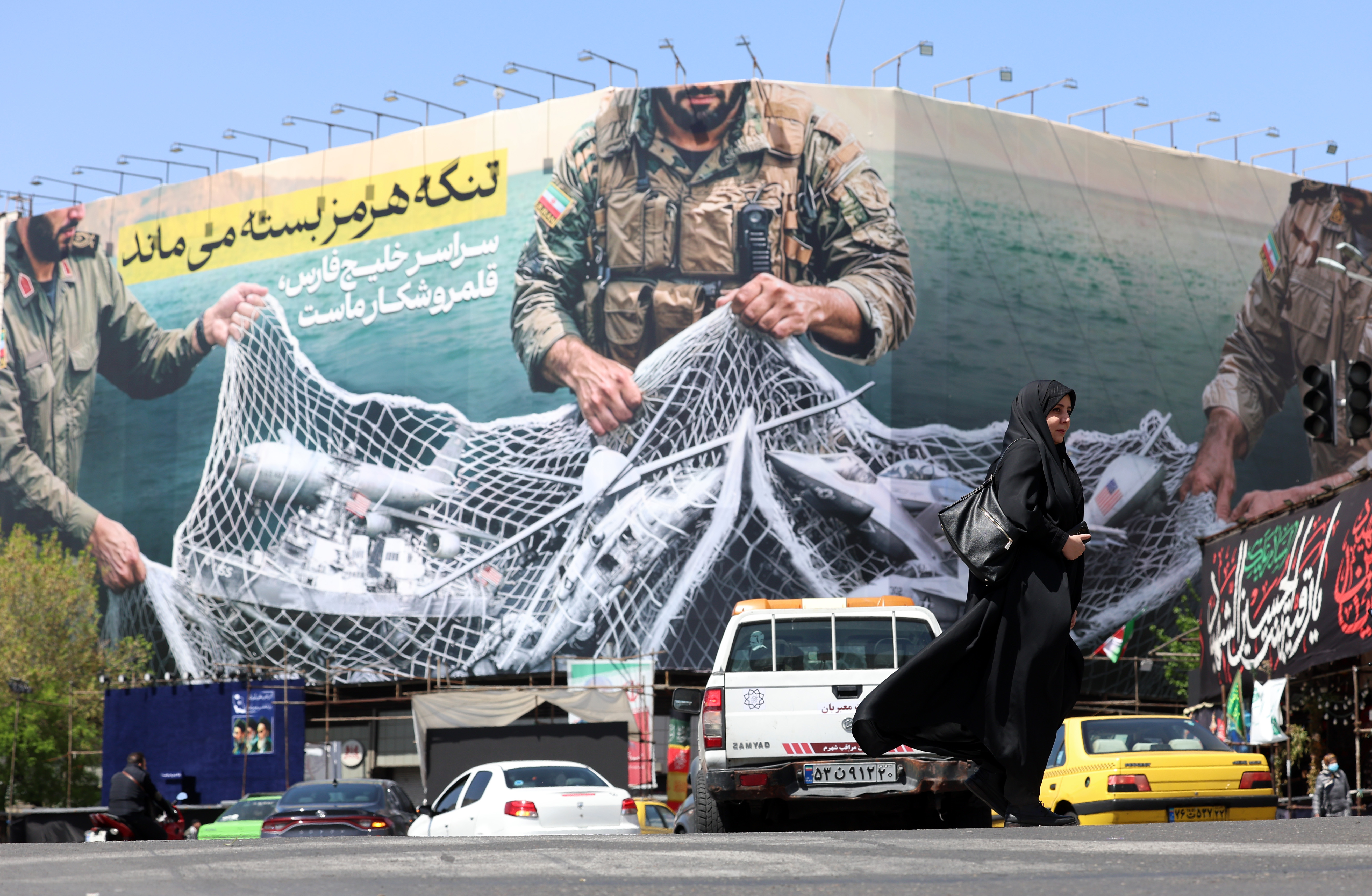 epa12870208 Traffic passing a huge political billboard reading in Persian ’The Strait of Hormuz will remain closed', in Enghelb square in Tehran, Iran, 05 April 2026. Iran's Revolutionary Guards (IRGC) said a US aircraft that had been searching for the crew member of a missing US fighter jet had been destroyed, Iranian media reported on 05 April 2026. EPA/ABEDIN TAHERKENAREH