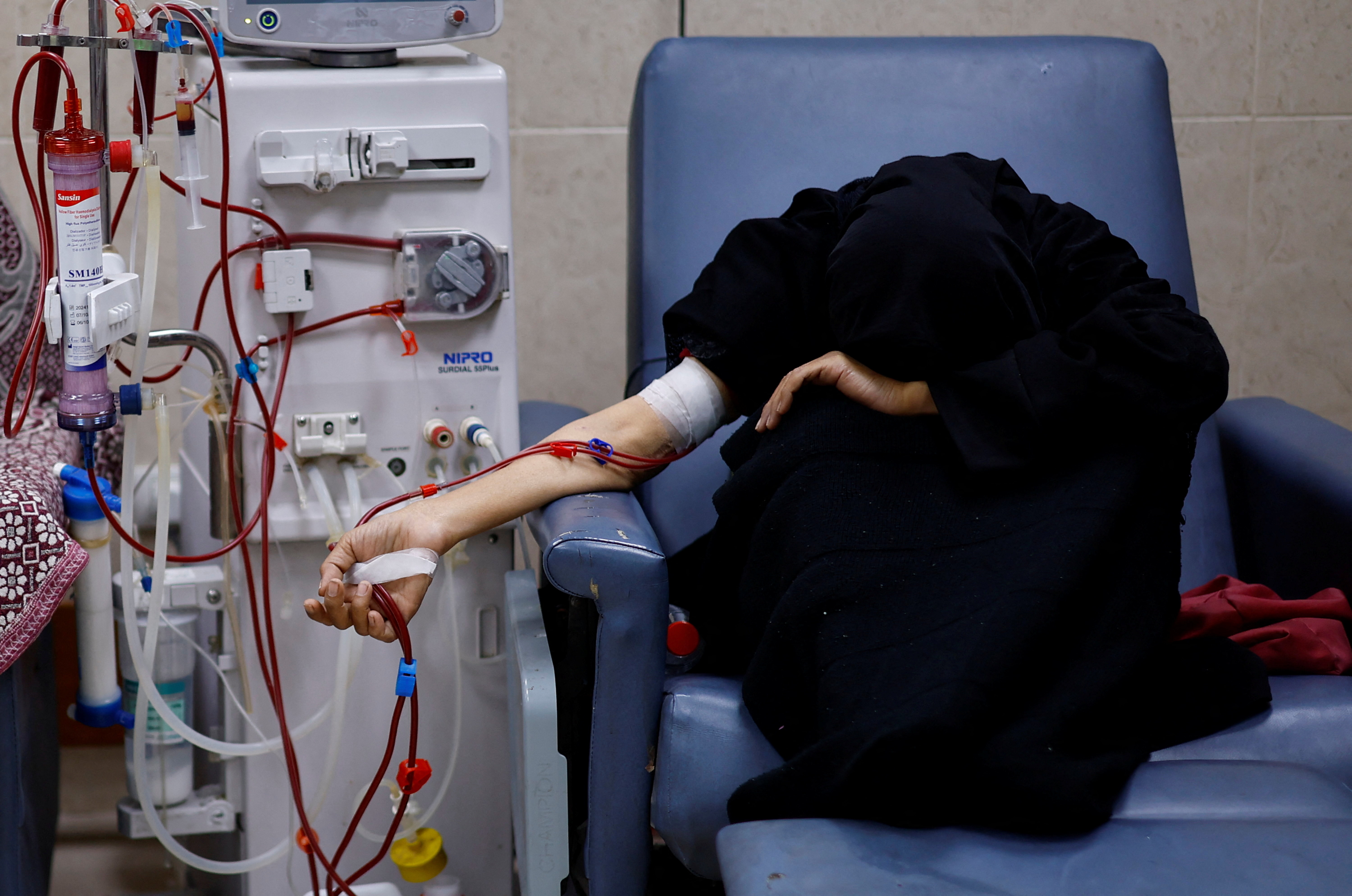 A Palestinian woman with kidney failure who hopes to leave Gaza through the Rafah crossing to have further treatment abroad, undergoes dialysis treatment