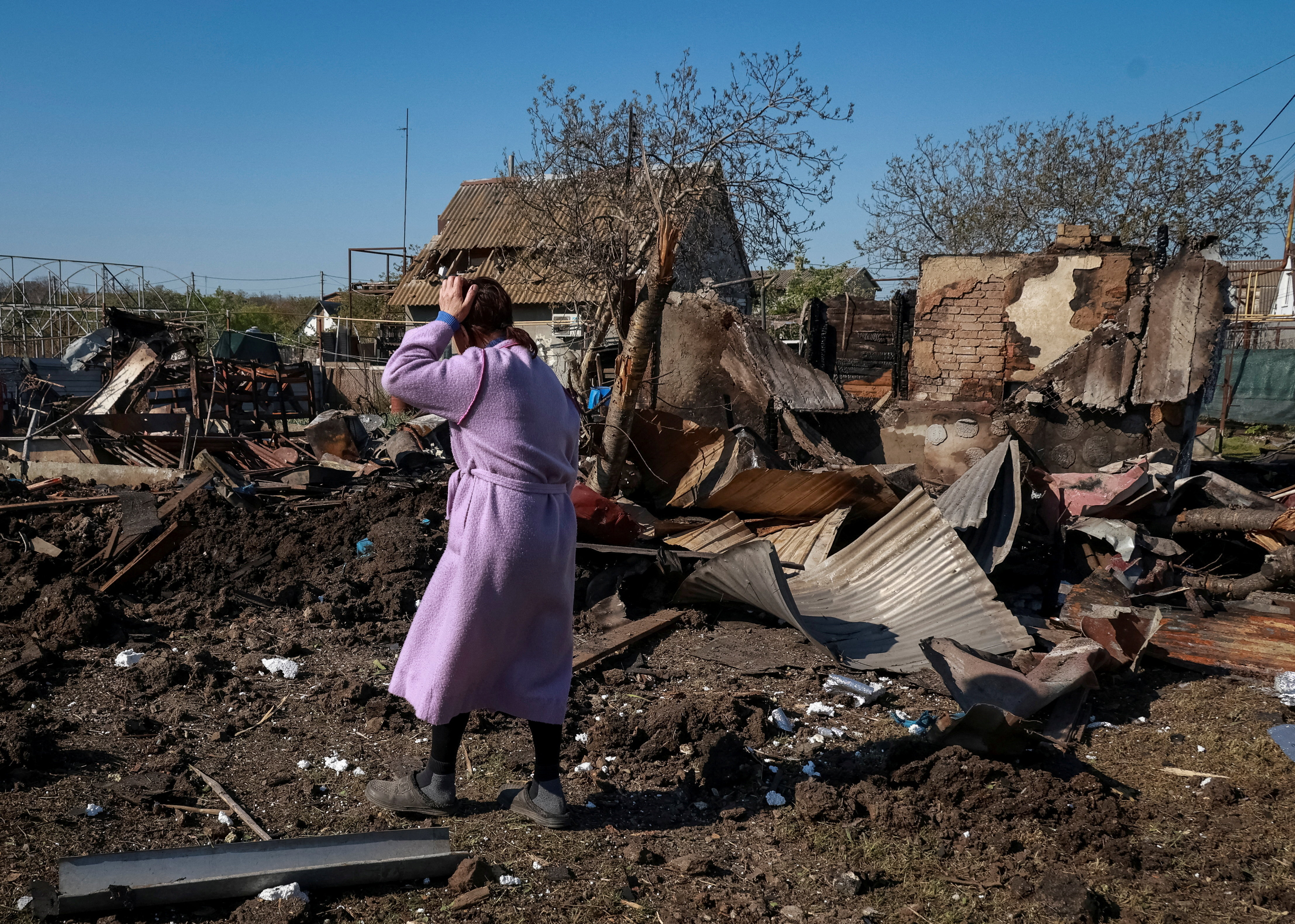 A resident walks at the site of a Russian drone strike, amid Russia's attack on Ukraine, near the city of Chornomorsk, Odesa region, Ukraine May 3, 2026. REUTERS/Nina Liashonok TPX IMAGES OF THE DAY
