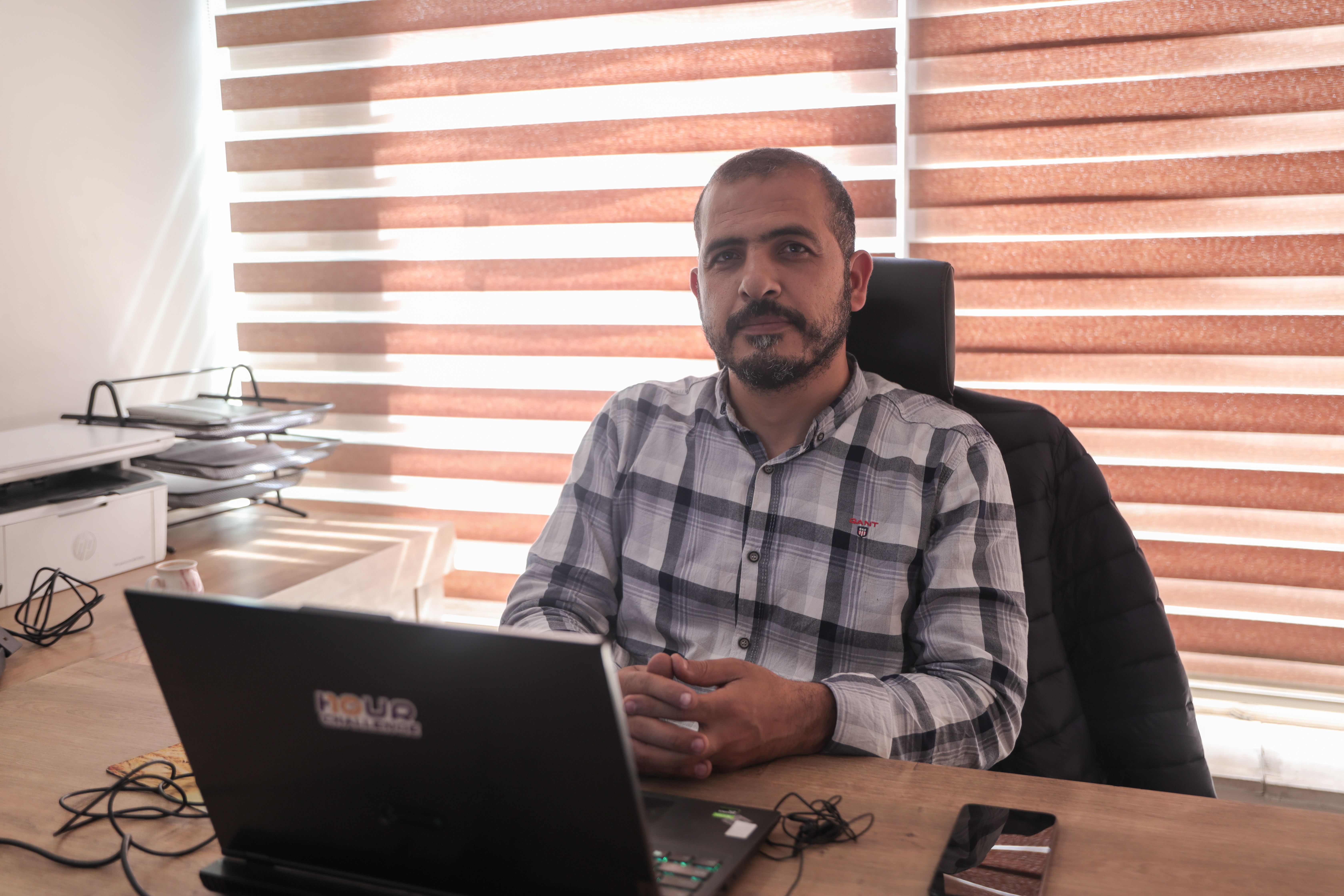 Man sits at desk with laptop open