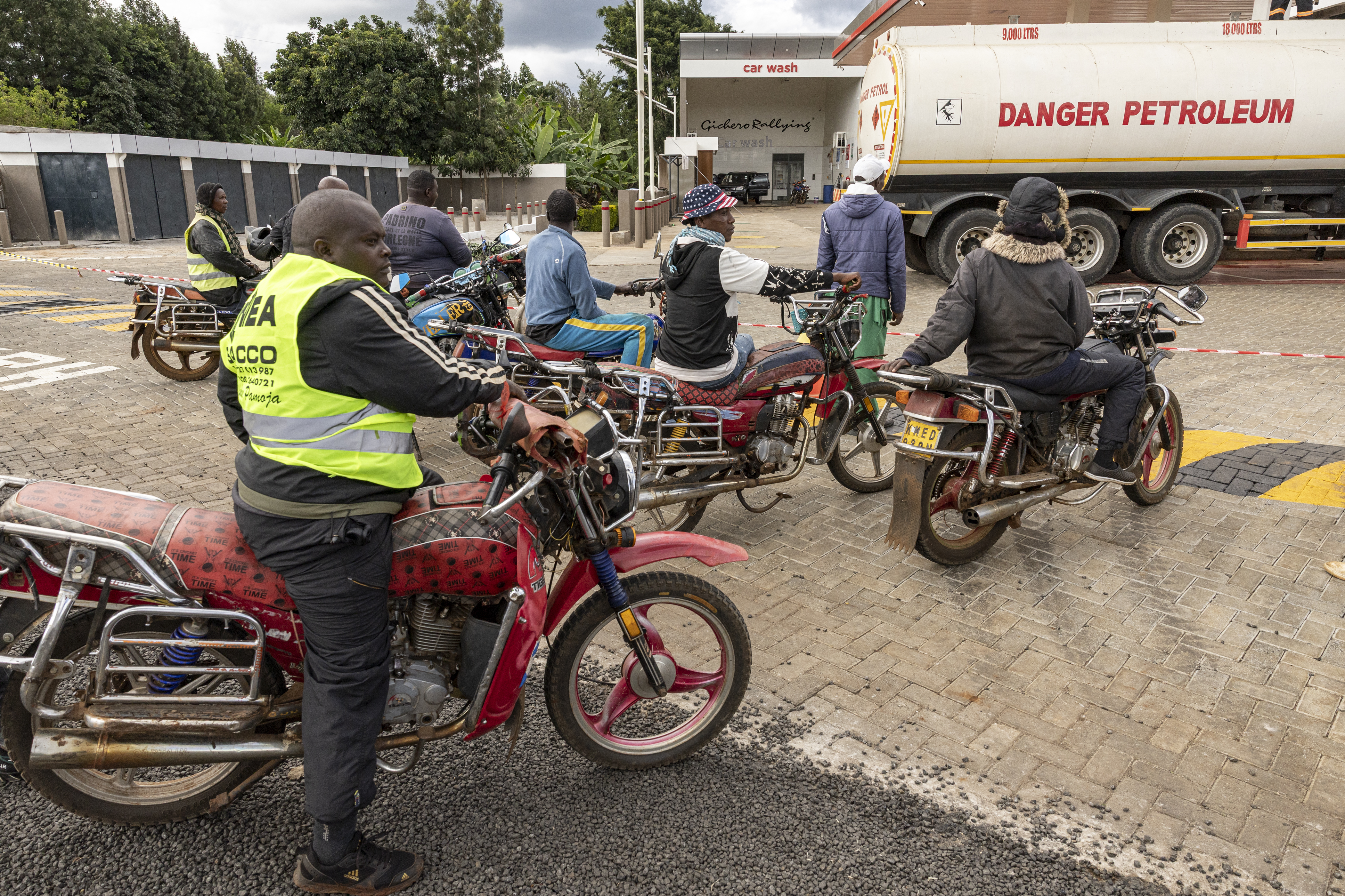 Motorcycle taxi drivers queue to refuel at a Total petrol station in Karatina