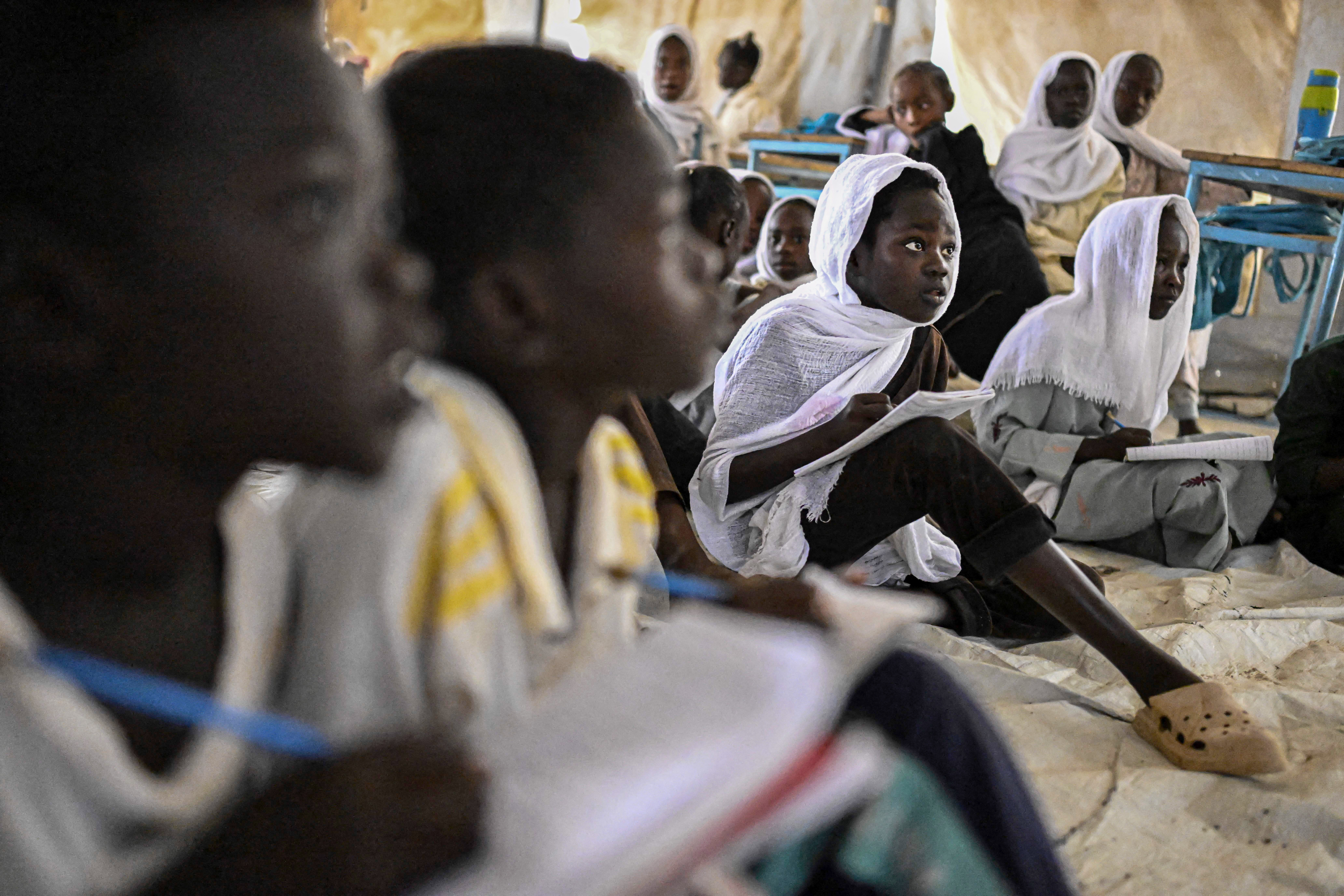 Displaced Sudanese students attend a class at an elementary school run by the Sudanese Coalition for Education in partnership with the United Nations International Children's Emergency Fund (UNICEF), south of Port Sudan, on April 26, 2026. In Sudan, where a war between the army and the paramilitary Rapid Support Forces has killed tens of thousands and triggered one of the worldís largest humanitarian crises, more than eight million children are currently out of school, according to the UNís childrenís agency. (Photo by Khaled DESOUKI / AFP)