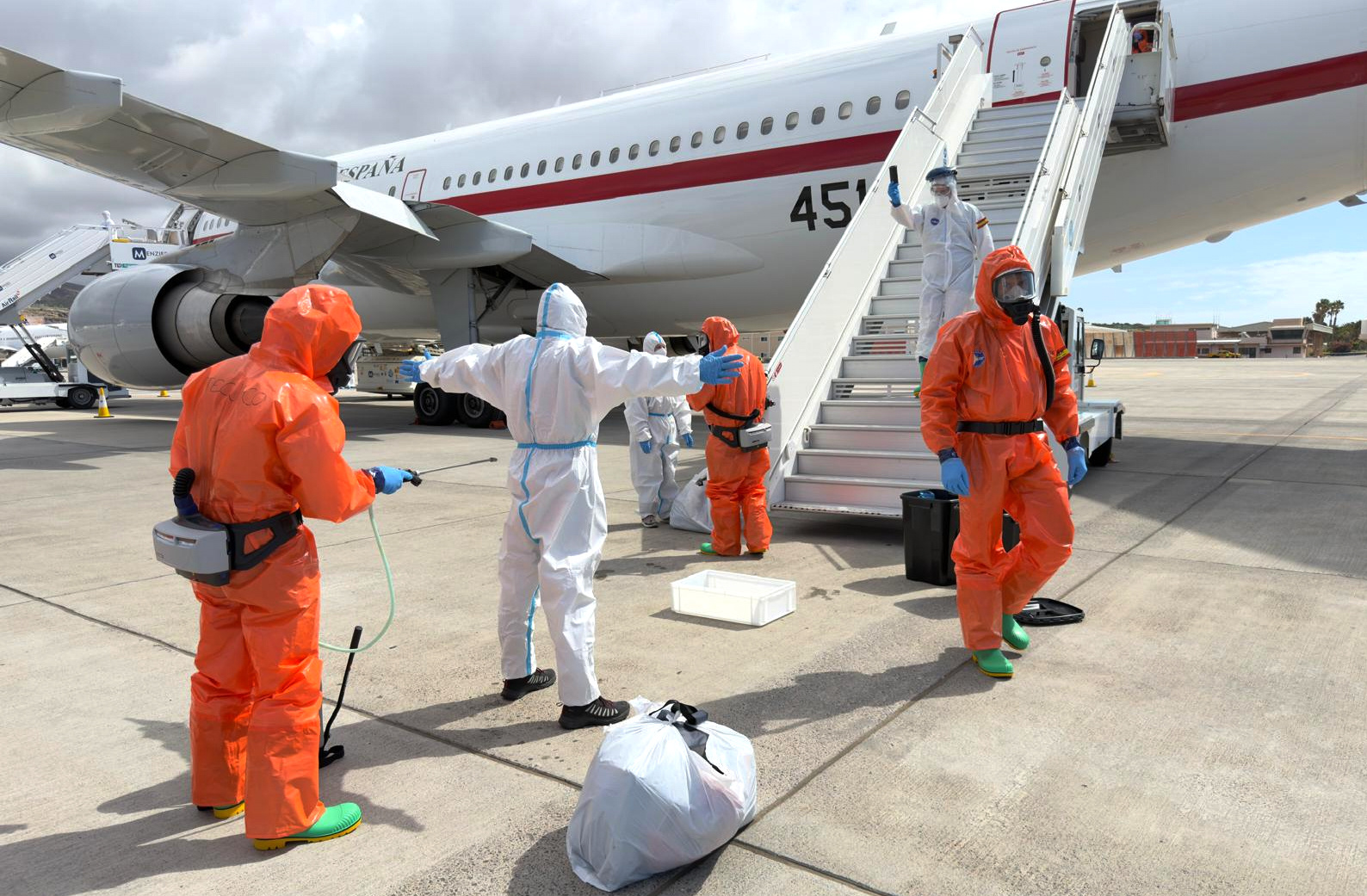 A passenger is sprayed with disinfectant by Spanish officials