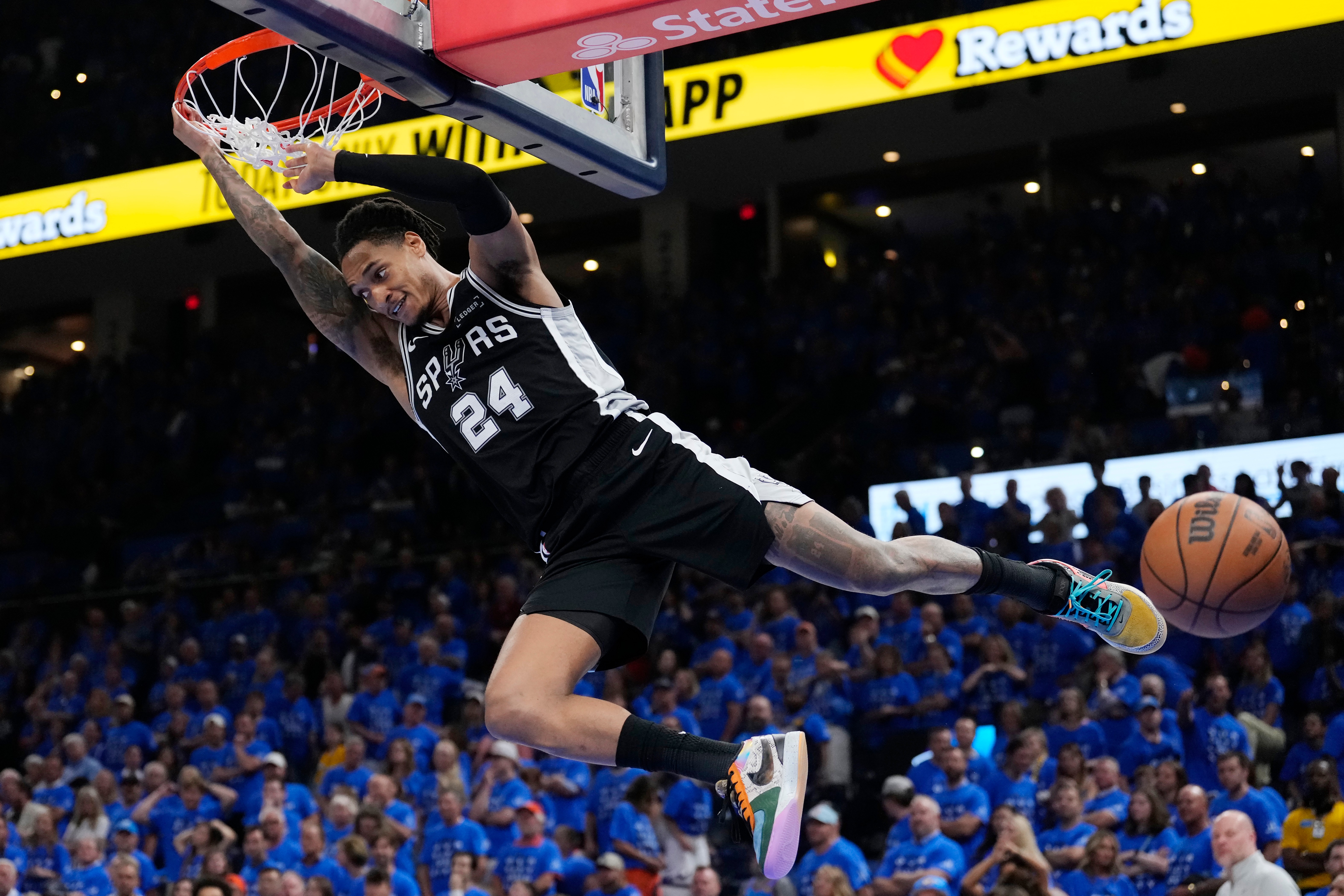 San Antonio Spurs guard Devin Vassell hangs on the rim after a dunk against the Oklahoma City Thunder during the second half of Game 7 of the Western Conference finals of the NBA basketball playoffs series, Saturday, May 30, 2026, in Oklahoma City. (AP Photo/Tony Gutierrez)