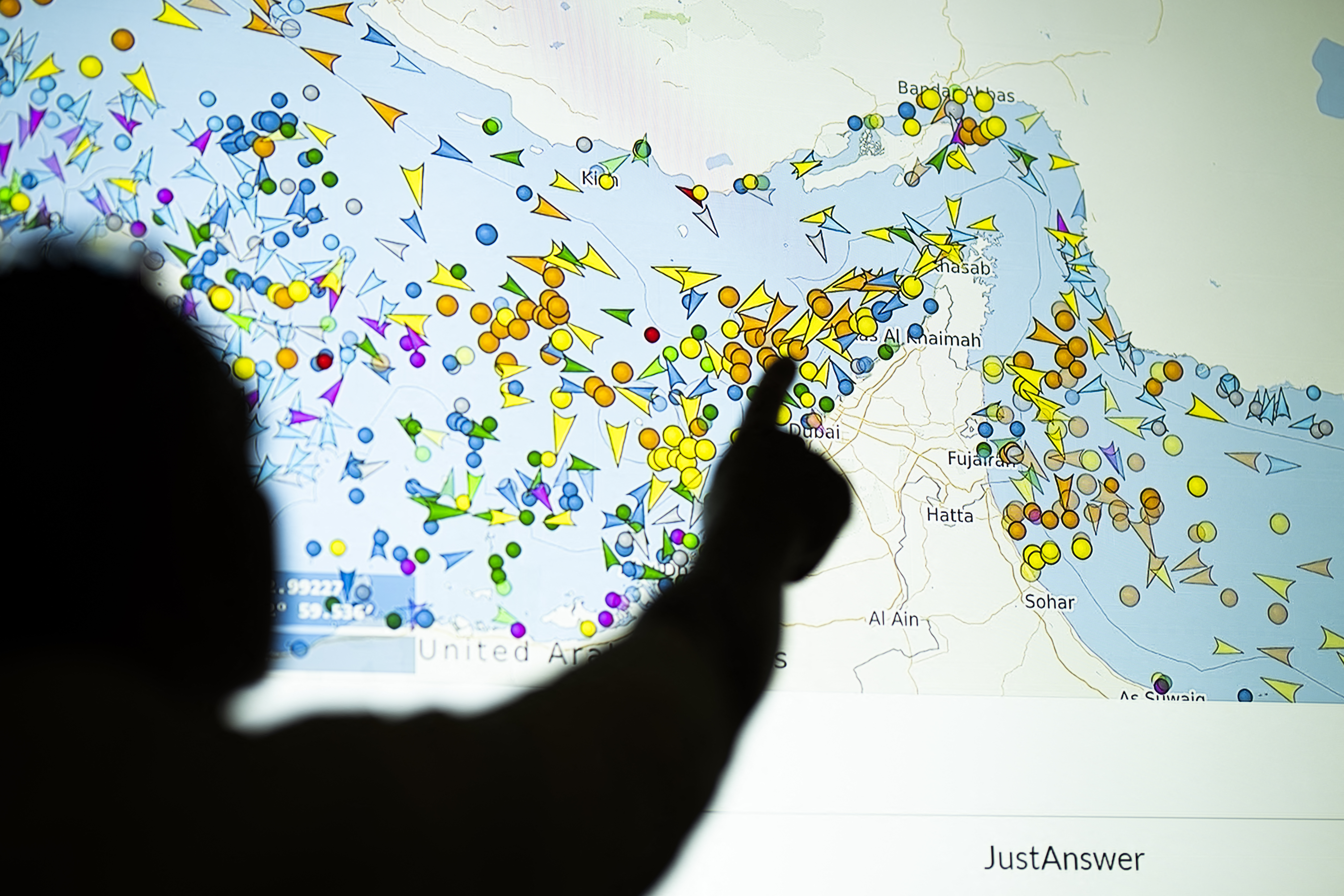 TOPSHOT - A photo illustration taken in Nicosia on May 4, 2026, shows a person in front of a large screen displaying vessel movements in the Strait of Hormuz on a ship-tracking website.