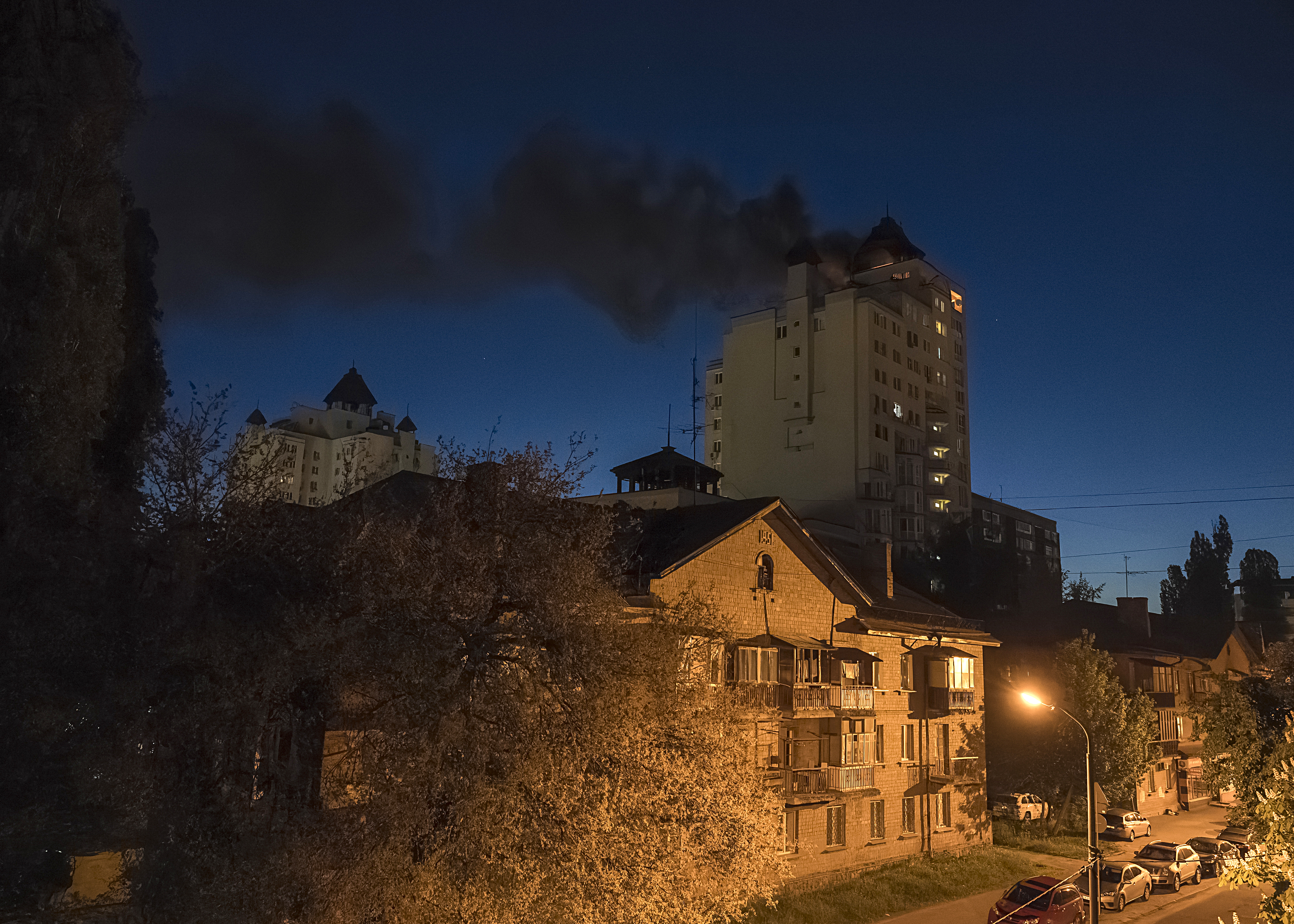 Smoke billows after debris from an intercepted Russian drone fell on the roof of a high-rise residential building in Kyiv