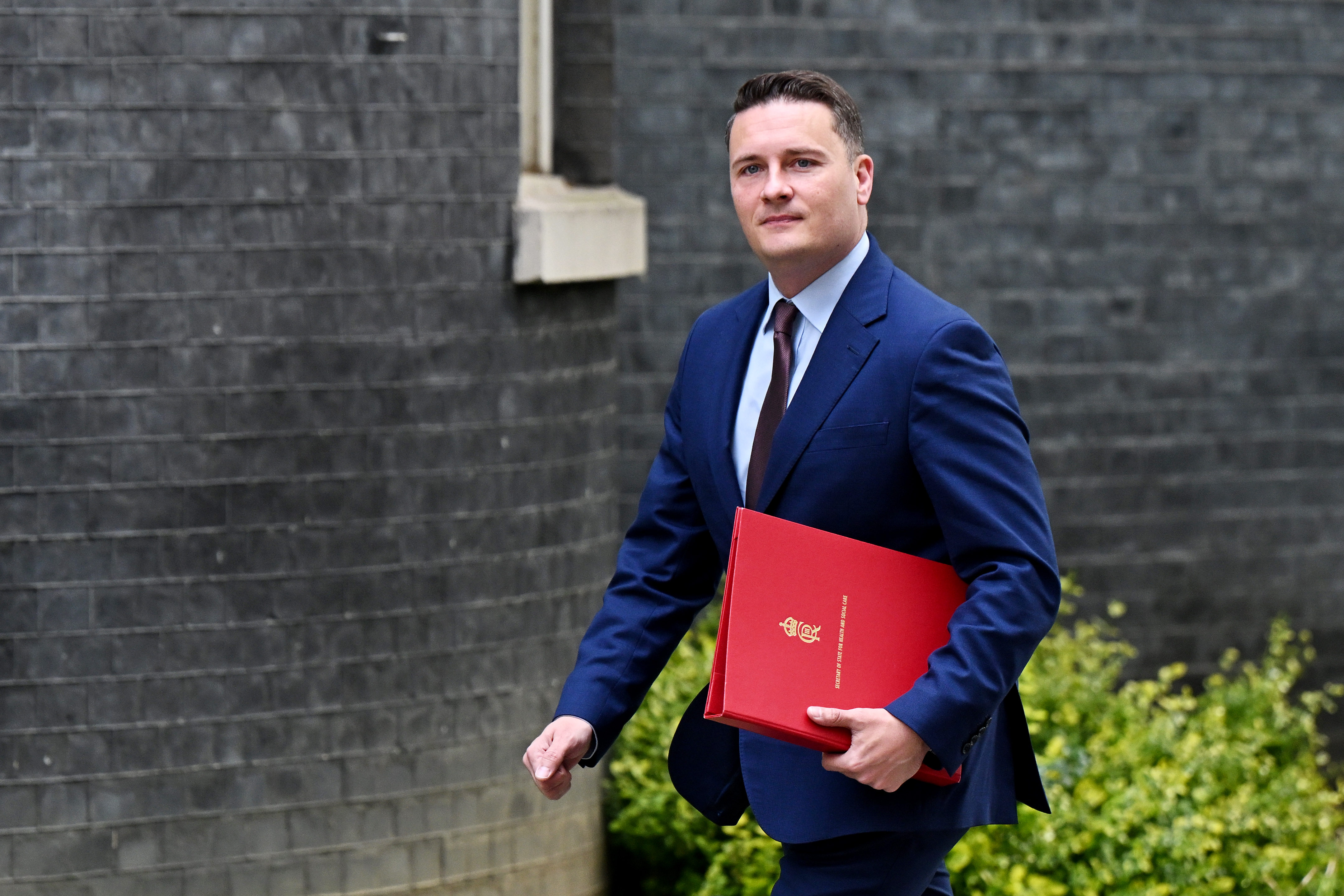 British Health and Social Care Secretary Wes Streeting arrives at Downing Street carrying a file.